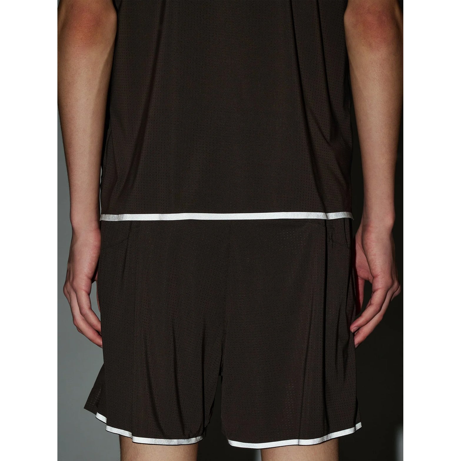 Goldwin Men's Air Pit Tank Jet Brown back view close-up showing reflective strips at rear hem for visibility during early morning and evening runs