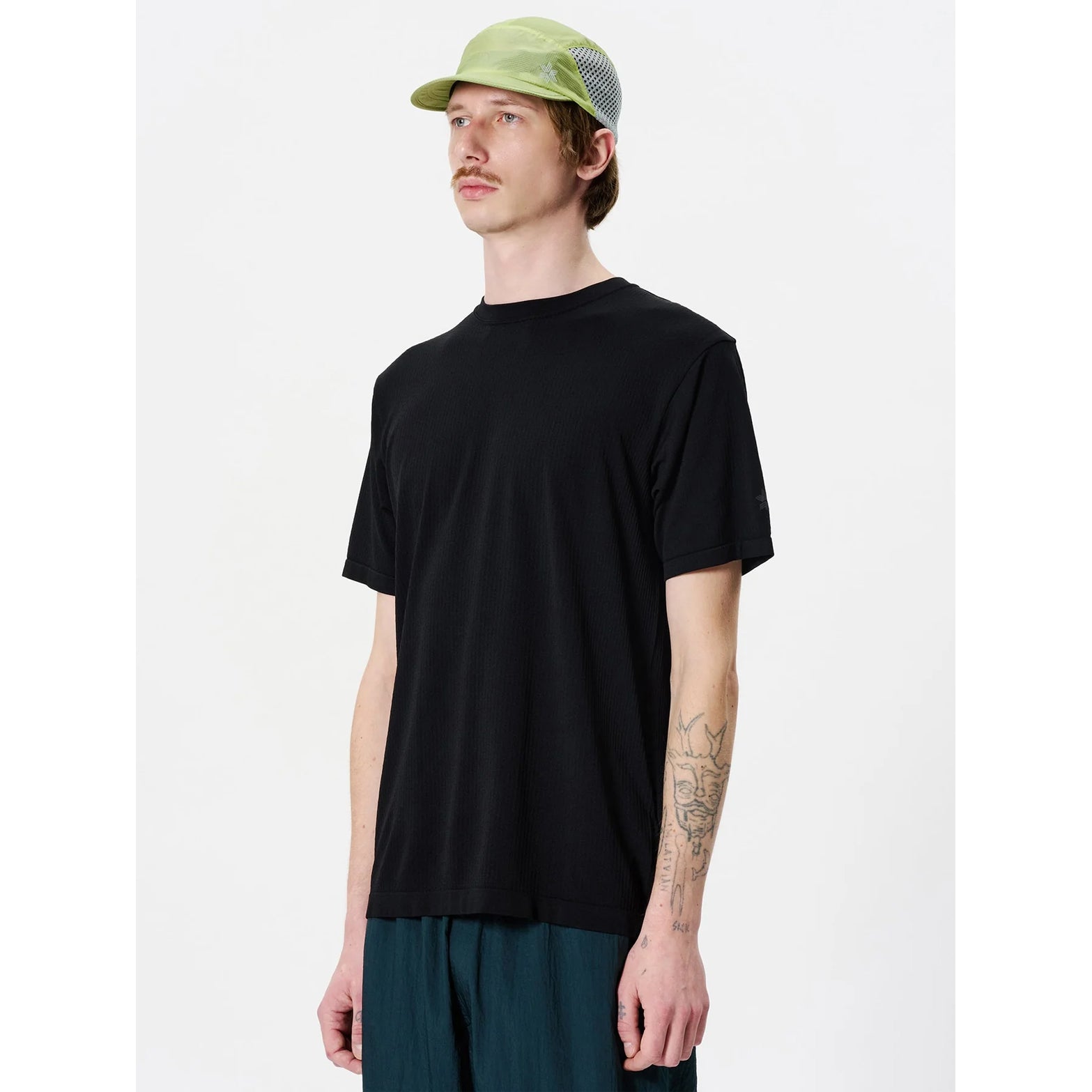 Goldwin Men's Convexity Dry Tee side view on male model showing seamless construction with denser weave in armpit zones for enhanced comfort