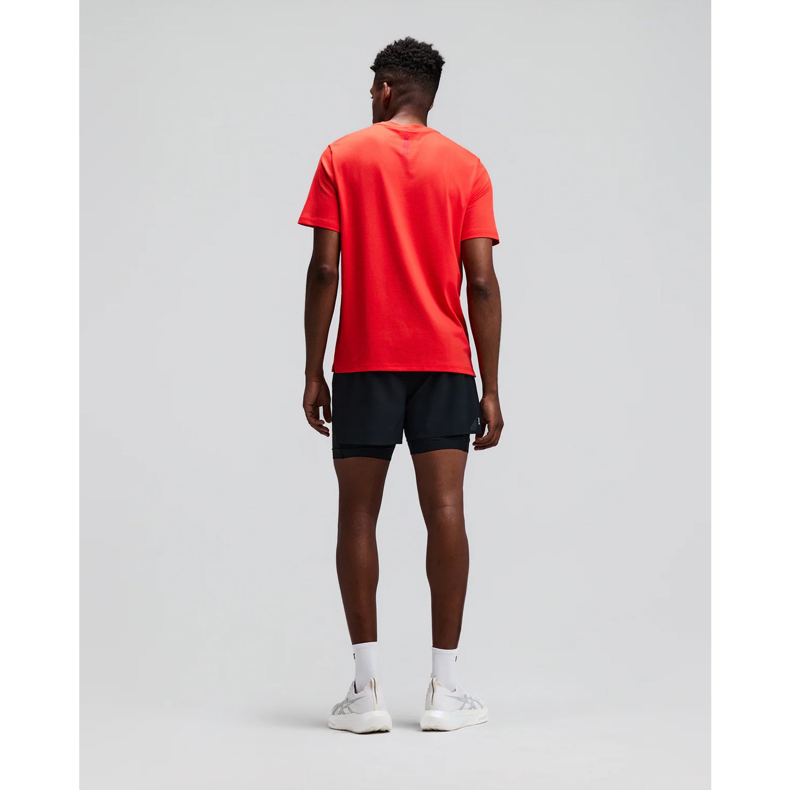 Men's Bandit CoolGrid 2-in-1 Run Short Black back full body view on male runner showing GripDot hem grip with reflective centre back branding and CoolGrid breathable construction