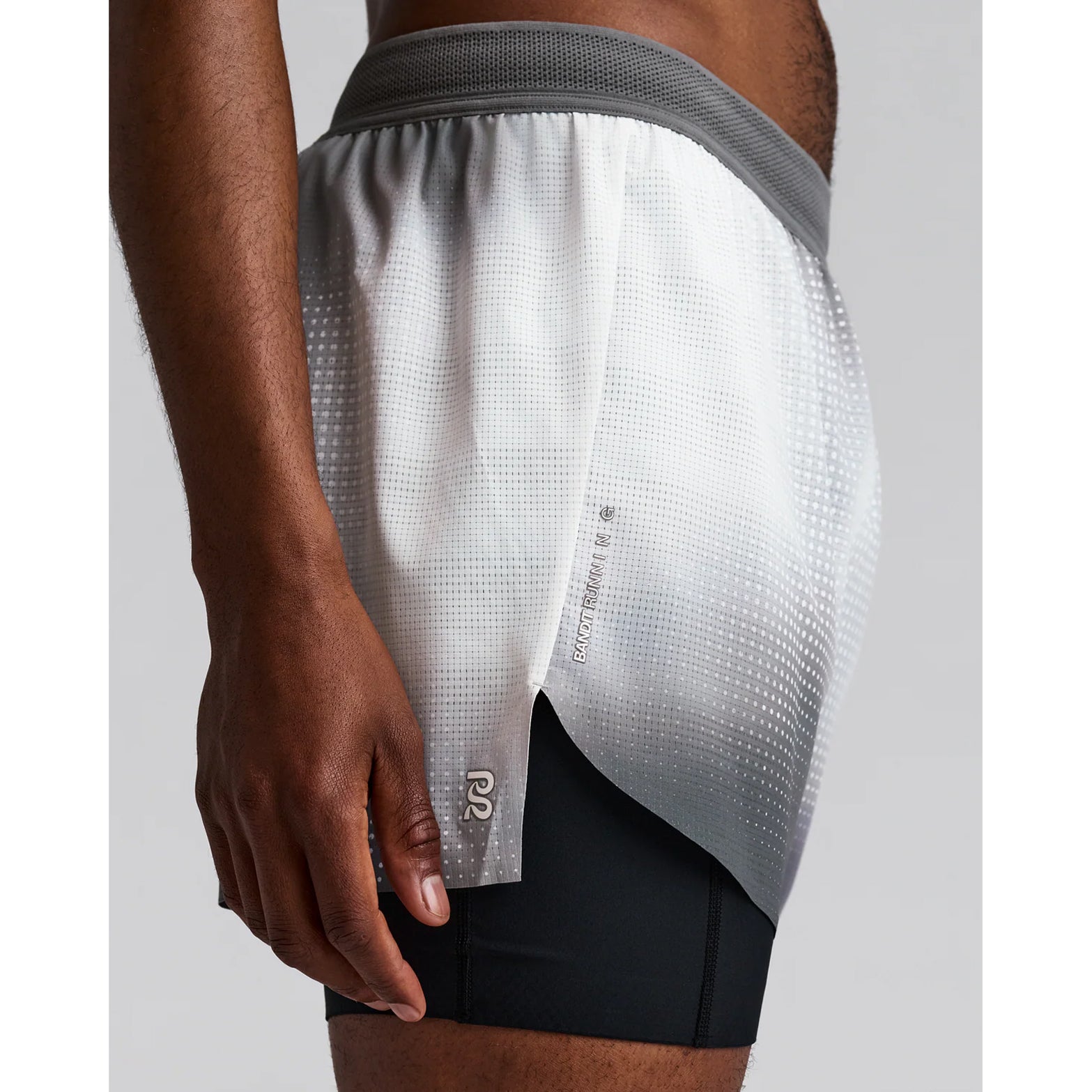 Men's Bandit CoolGrid 2-in-1 Run Short Micro Geo Gradient Slate Plaster side view on male runner showing Micro Geo Gradient CoolGrid breathable outer with GripDot hems and waterproof leg pocket for comfortable running and racing