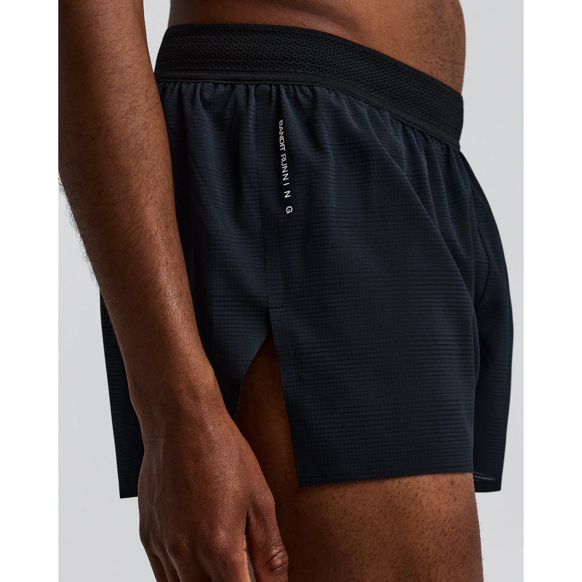 Men's Bandit CoolGrid 3 Inch Split Shorts Black side view on male runner showing 3-inch split design with mid-rise fit, CoolGrid breathable fabric and bonded anti-chafe construction for comfortable road running and racing