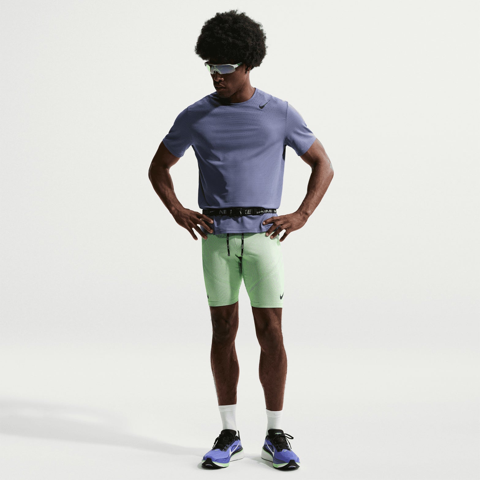 Men's Nike Dri-FIT AeroSwift ADV Half Tights Green full body front view on male runner showing 1/2-length racing cut with brief liner and branded drawcords