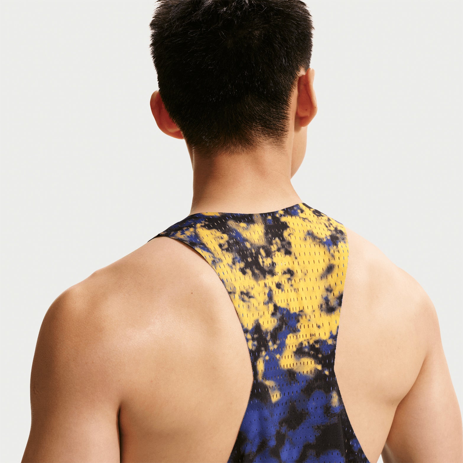 Men's Nike Dri-FIT AeroSwift ADV Running Vest Citron Pulse Lapis Bright Crimson back view on male runner showing racing vest construction with advanced sweat-wicking technology for competition