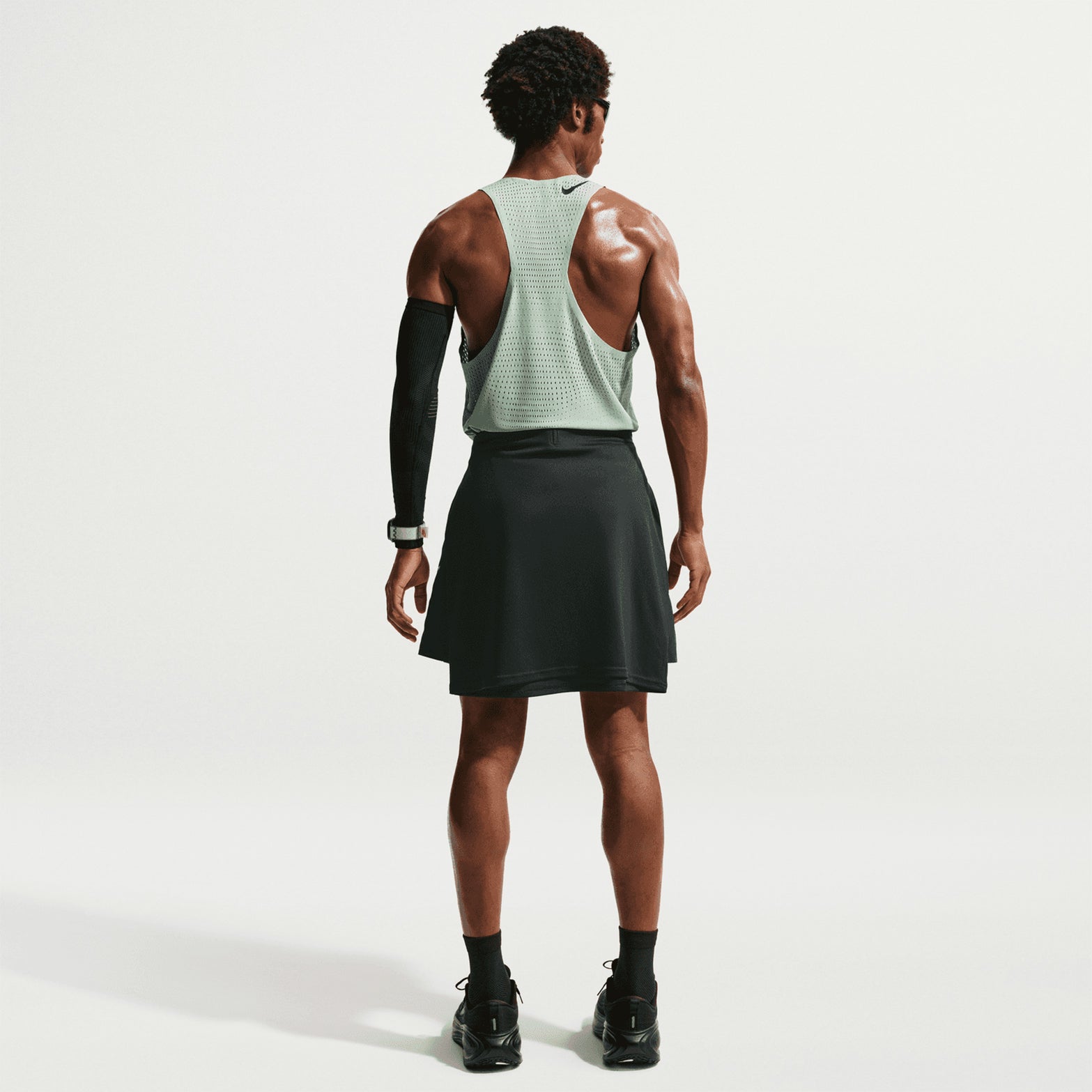 Men's Nike Dri-FIT AeroSwift ADV Running Vest Green full body back view on male runner showing bonded seams at armhole and collar for chafe-free racing