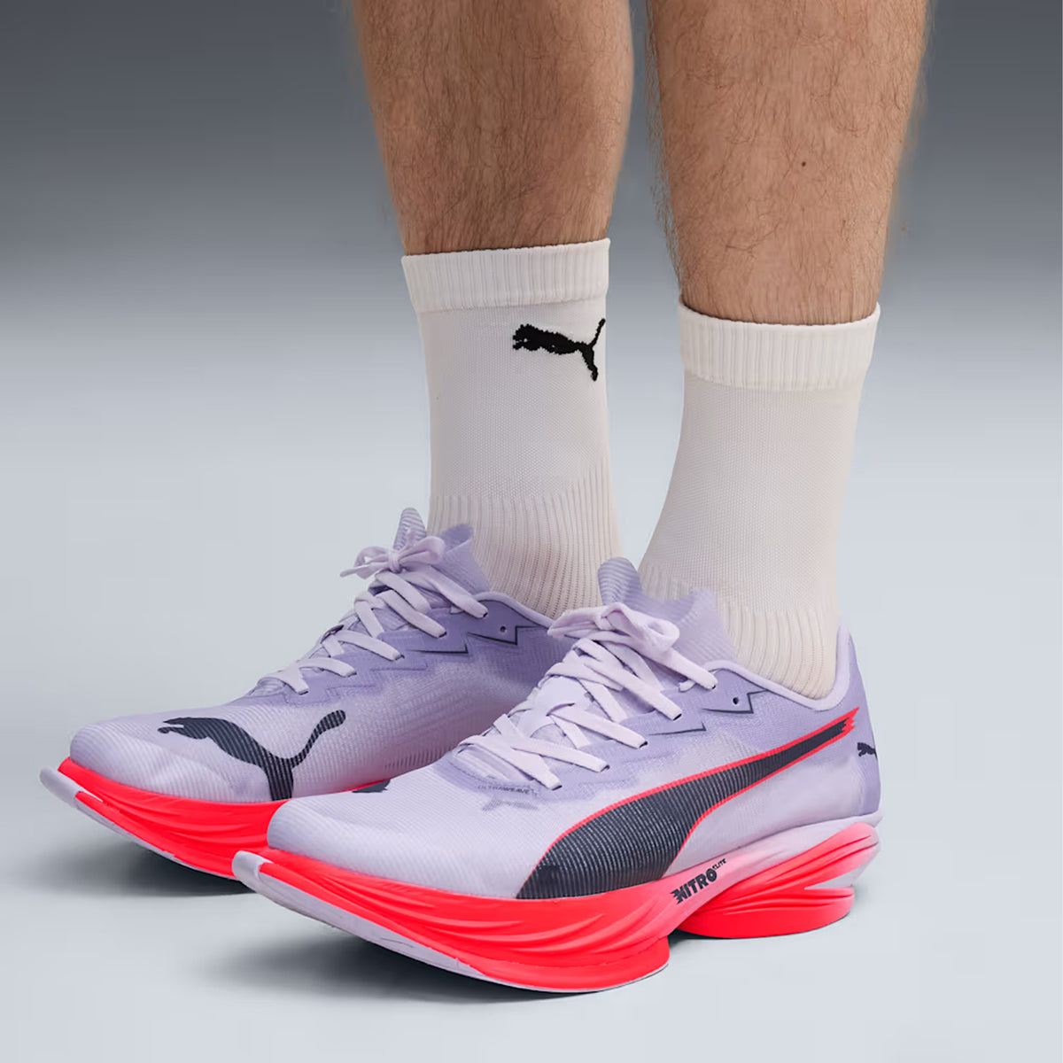 Puma FAST-R Nitro Elite 3 men's running shoe in Light Lavender / Ultra Red — side view worn on model showing light lavender ULTRAWEAVE upper, aggressive de-coupled heel construction and ultra red NITROFOAM ELITE foam with extended carbon plate propulsion geometry