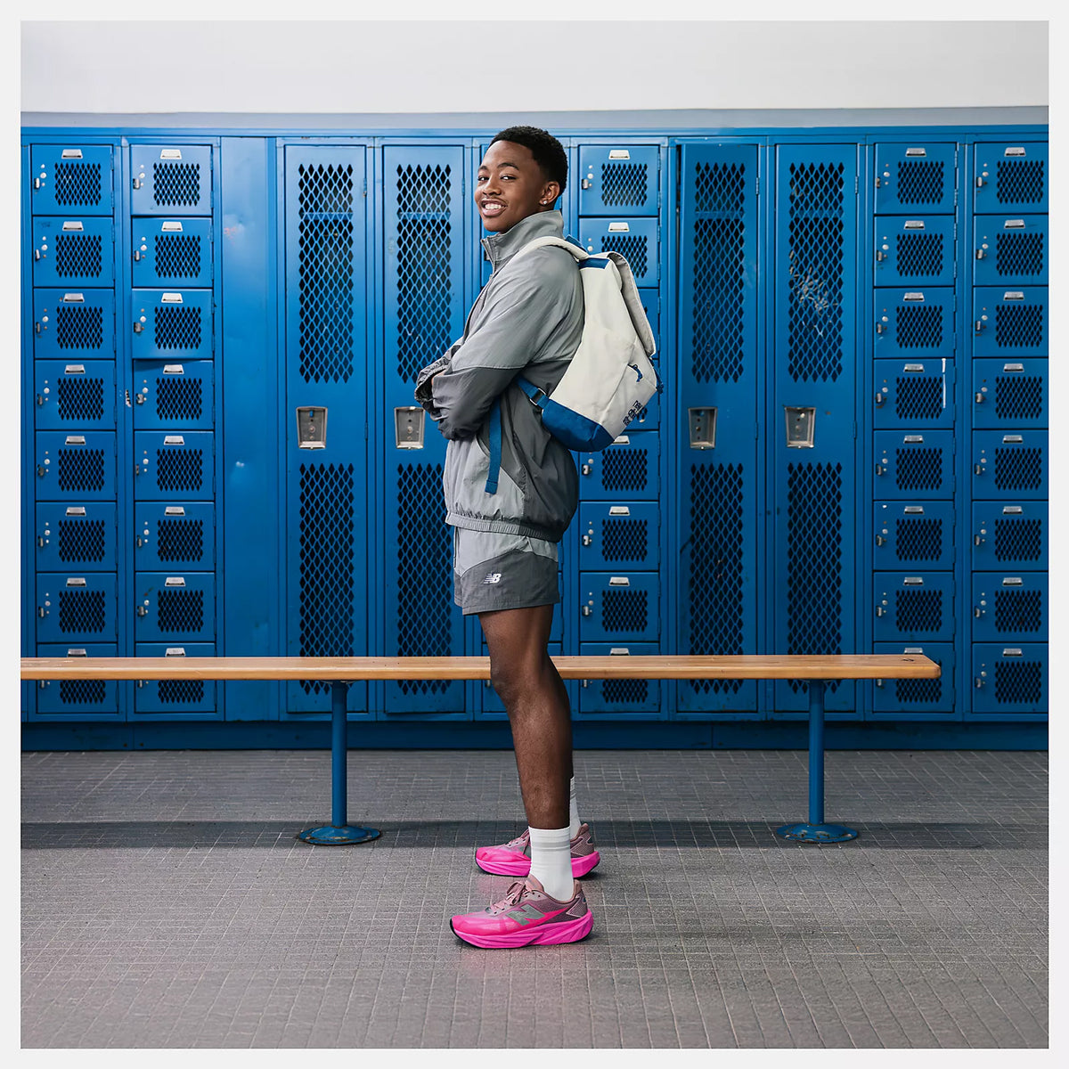 New Balance FuelCell Rebel v5 men's running shoe in Pink Heat / Rosewood — side view worn on model showing pink heat streamlined mesh upper, bold geometric FuelCell midsole profile and rosewood accent detailing 