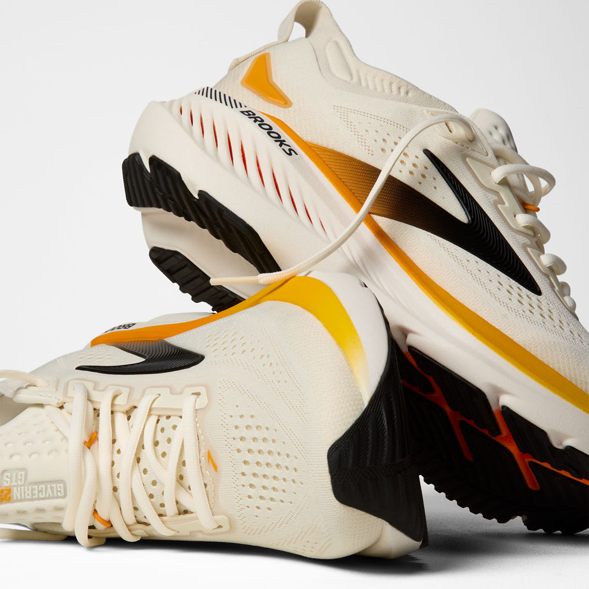 Brooks Glycerin GTS 23 men's running shoe in Arctic Wolf / Angora / Orange — angled side view showing arctic wolf engineered knit upper, GuideRails support sidewalls and angora DNA TUNED cushioning midsole stack with 8mm offset profile