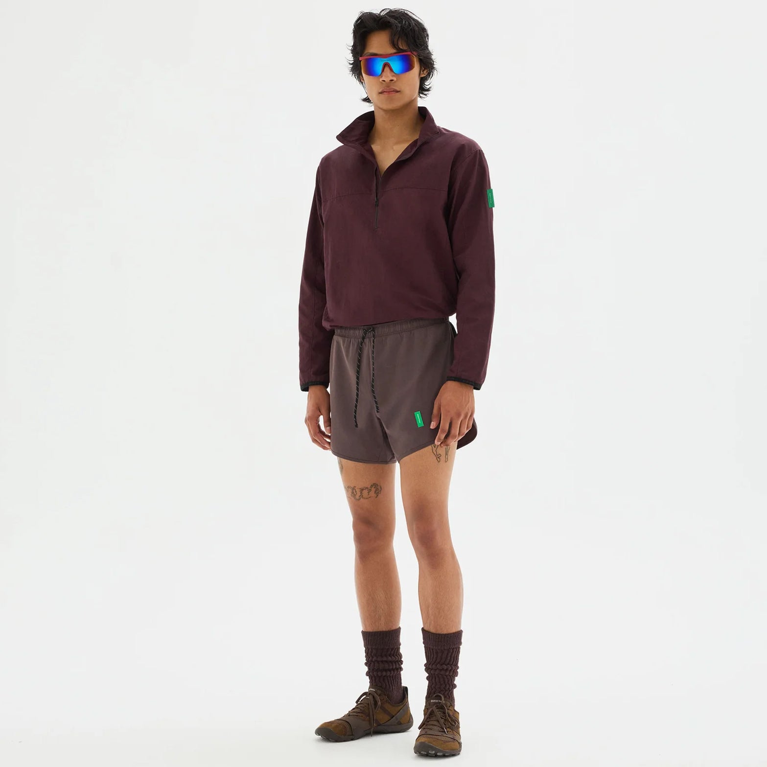 District Vision Men's Half Zip Nylon Windbreaker Blackberry full body view on male runner showing half-zip front with integrated eyewear storage and highly water-resistant Japanese shell fabric