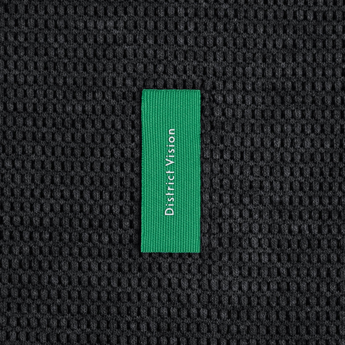 Men’s Hooded Waffle Top Black in a Korean cotton blend, featuring a waffle texture and a vertical green tag with District Vision text.