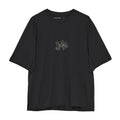 Introducing the Portal Men’s Lateral Peak Tee in Black Beauty—a loose-fitting technical T-shirt with short sleeves, crafted from recycled polyester and featuring a small, minimalist white floral line drawing centered on the chest.