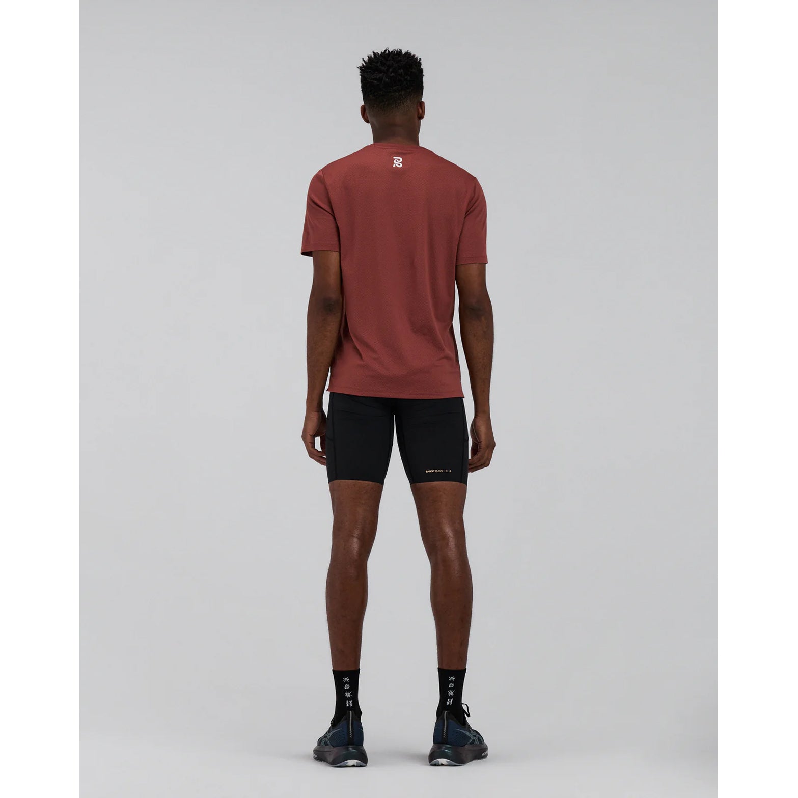 Men's Bandit Micromesh Run Tee Mahogany full body back view on male runner showing breathable Micromesh fabric with dyed-to-match reflective graphic for visibility