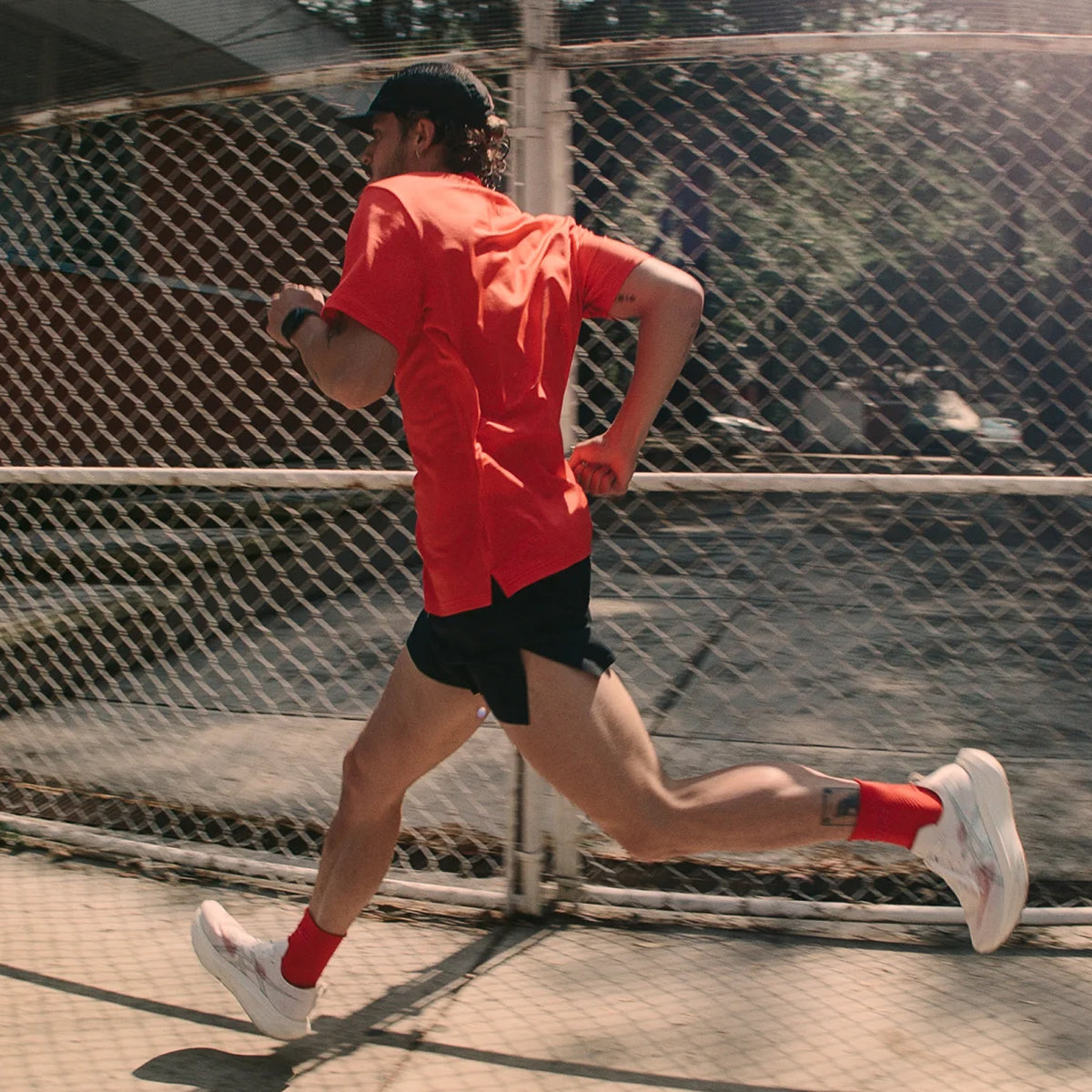 Men's Bandit Micromesh Run Tee Poppy side view on male runner in motion showing breathable Micromesh construction with fast-drying sweat-wicking fabric and relaxed fit for comfortable running
