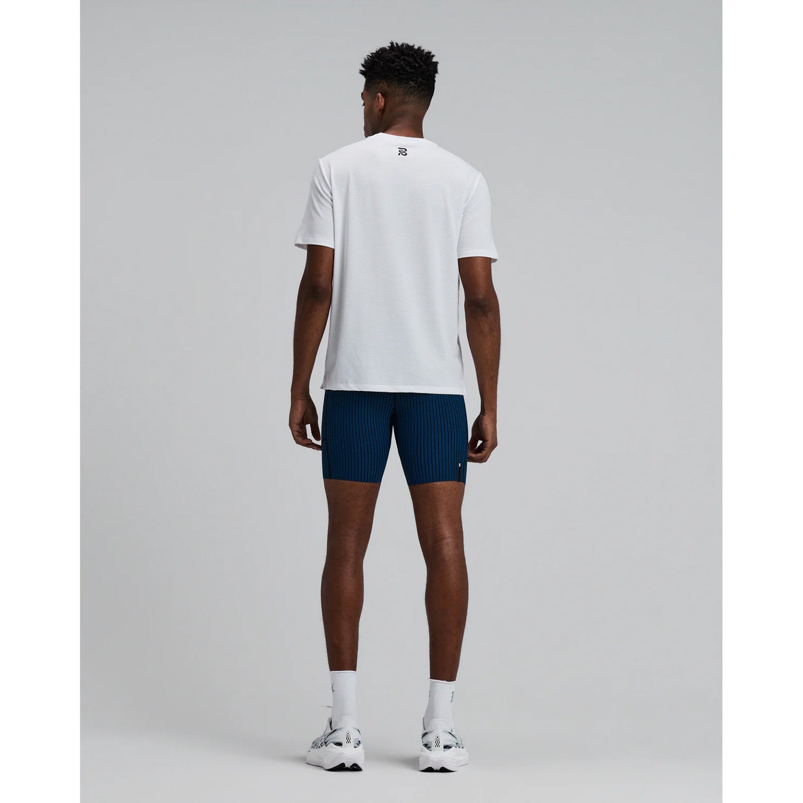 Bandit Micromesh Run Tee men's in White — full body back view worn on model showing relaxed fit silhouette, Micromesh™ breathable fabric construction and dyed-to-match reflective graphic at centre back