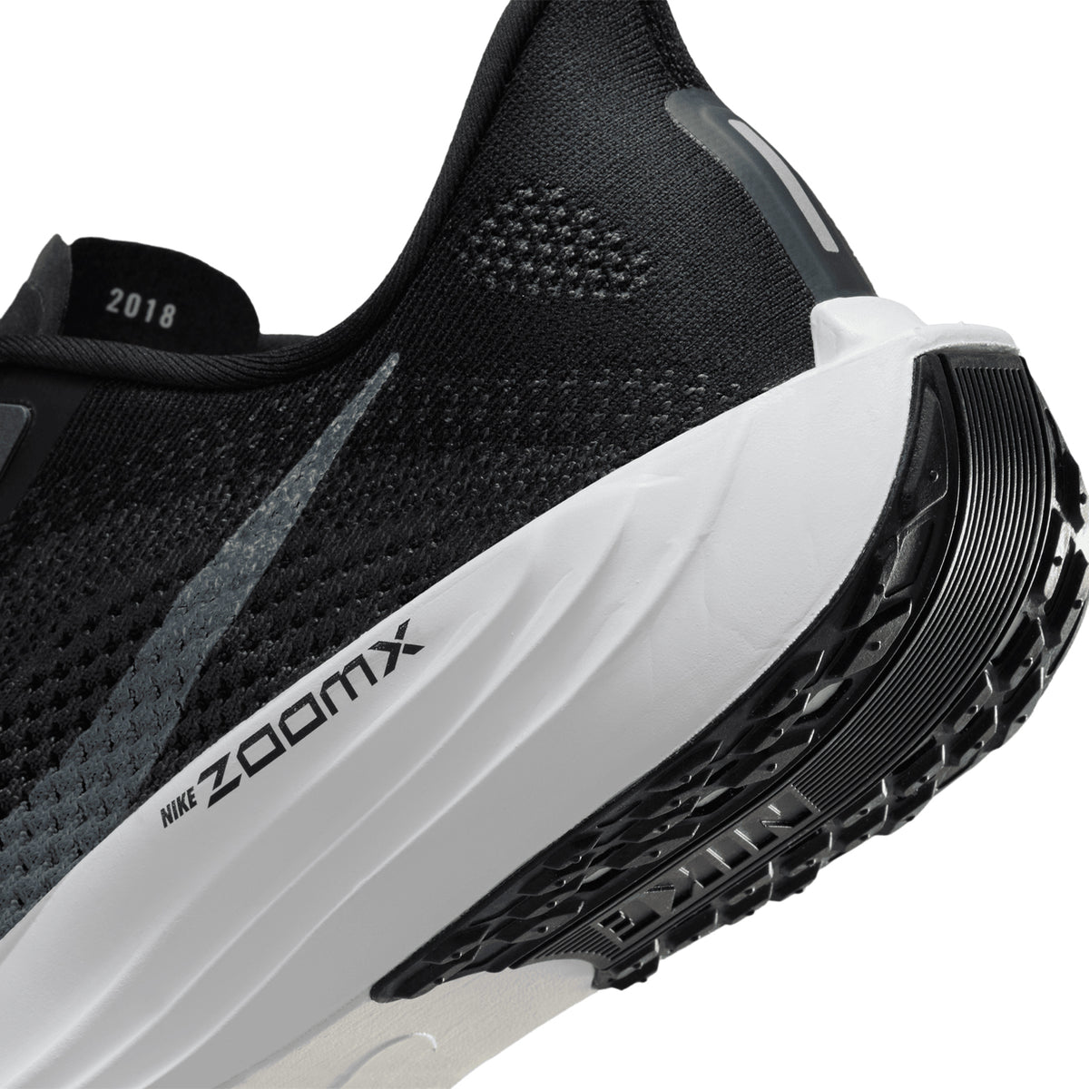 Men's Nike Pegasus Plus Running Shoes Black Pure Platinum Anthracite angled sole close-up showing high-abrasion rubber traction pattern and full-length ZoomX foam construction