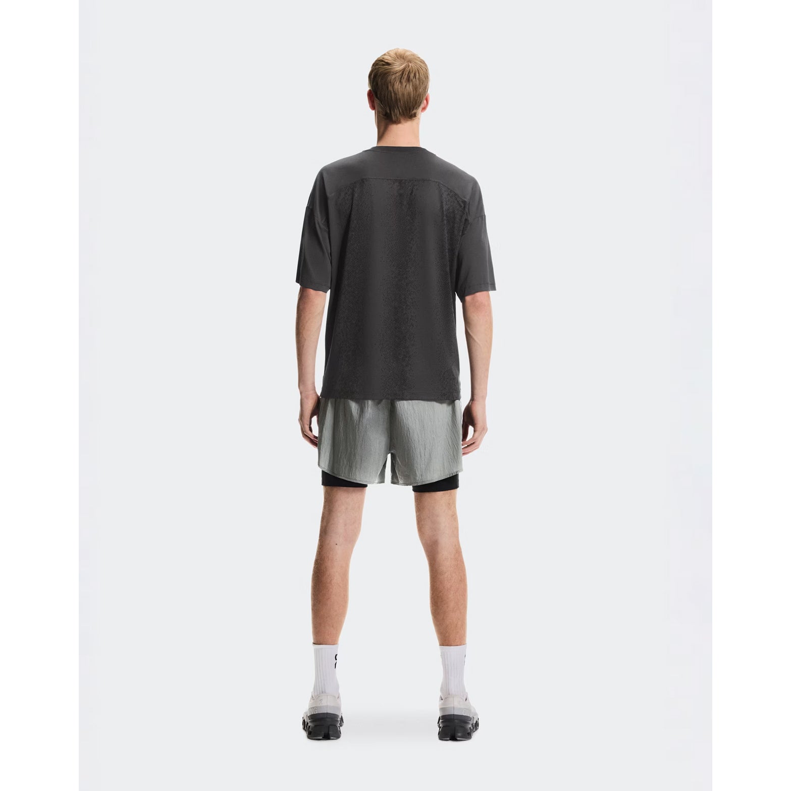Men's On Performance Volt-T Iron full body back view on male runner showing versatile relaxed cut with quick-dry moisture-wicking performance for everyday activities