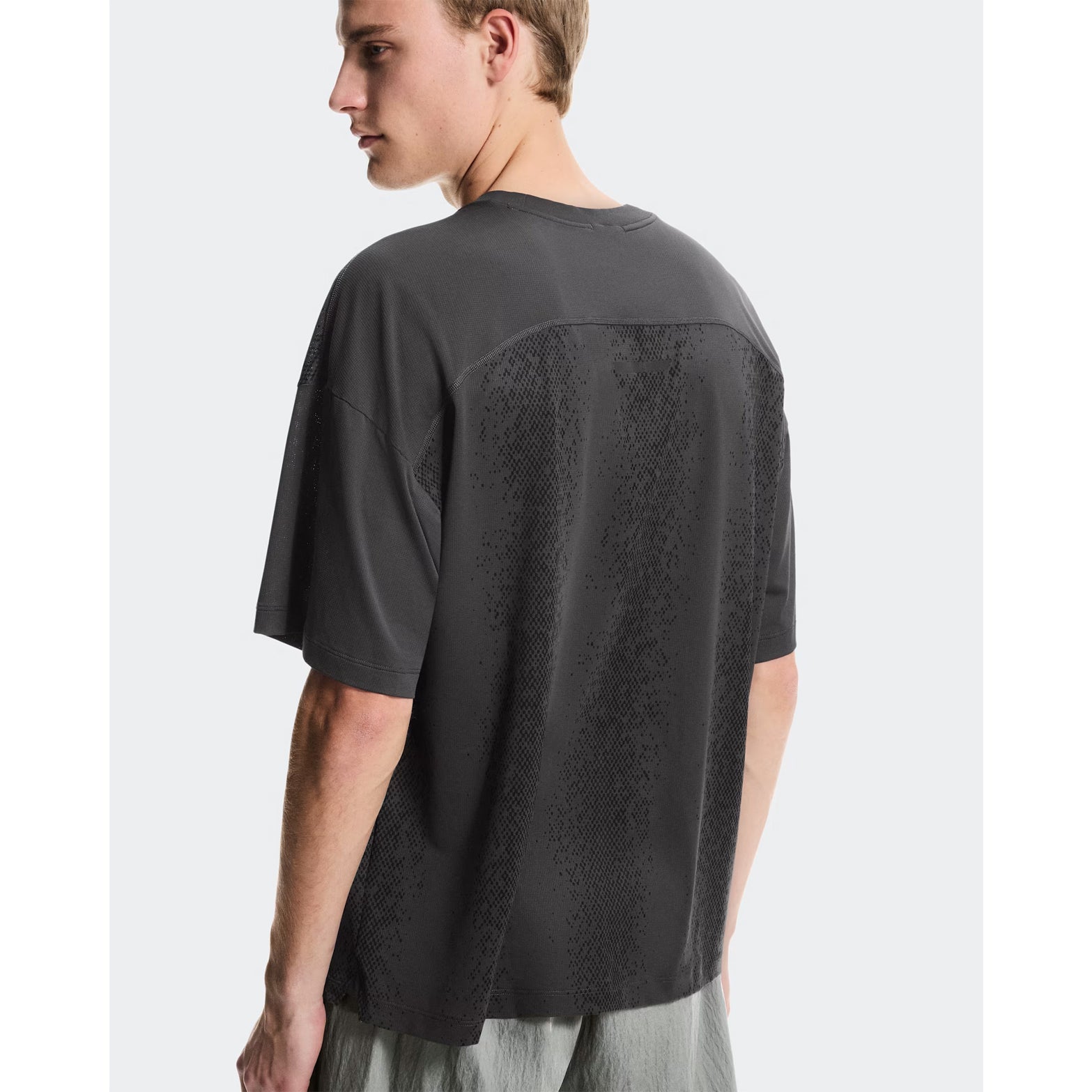 Men's On Performance Volt-T Iron back view on male runner showing relaxed fit with On DryTec technology for versatile training and recovery wear