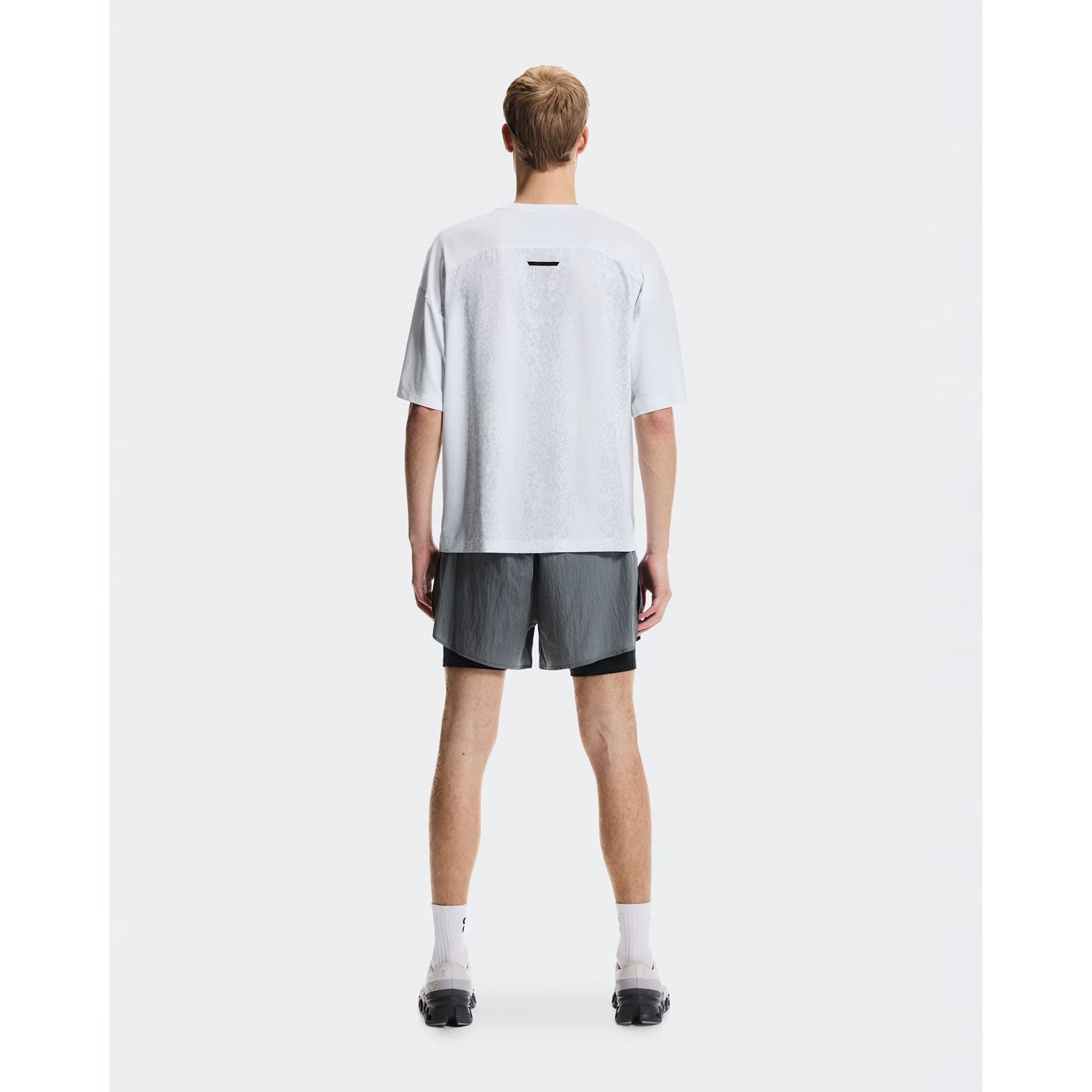 Men's On Performance Volt-T White full body back view on male runner showing versatile relaxed cut with quick-dry moisture-wicking performance for everyday activities