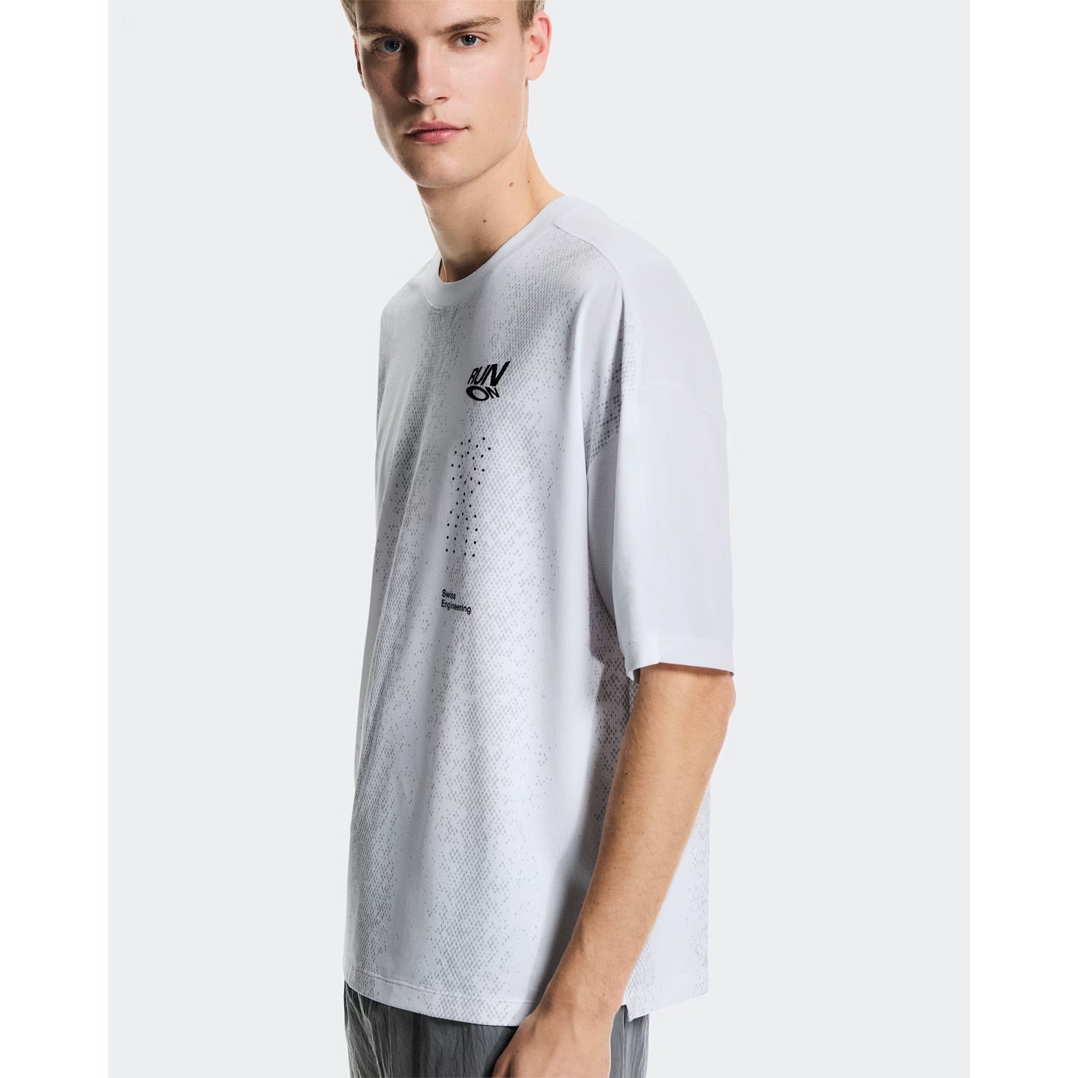Men's On Performance Volt-T White front view on male runner showing lightweight moisture-wicking construction with bold typographic run-culture design