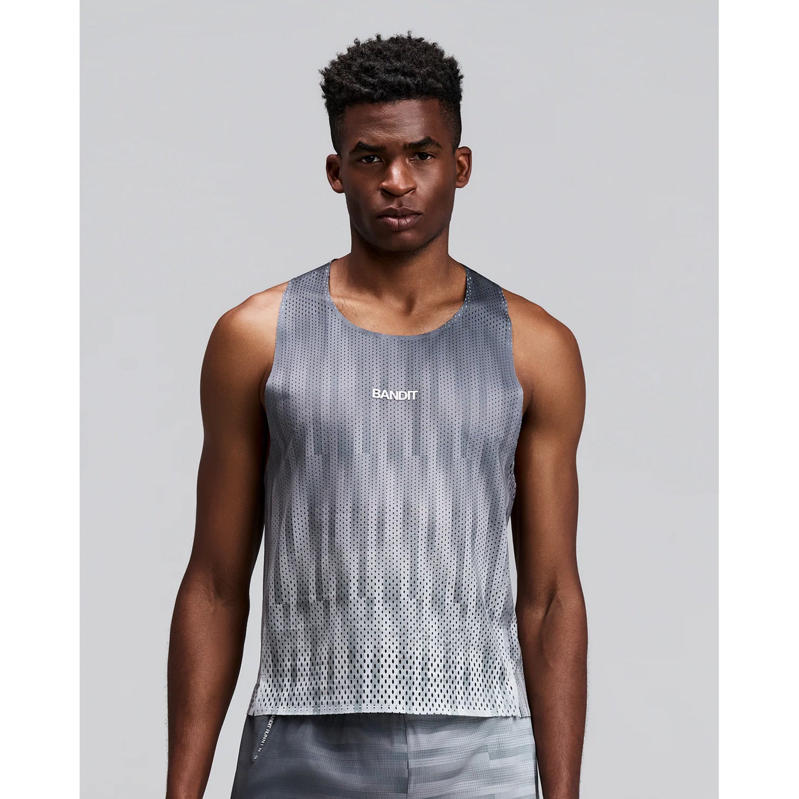 Men's Bandit Shredder Shorty Race Singlet Uneven Gradient Plaster front view on male runner showing cropped fit with two-tone reflective branding and Shredder gradient mesh for race day breathability