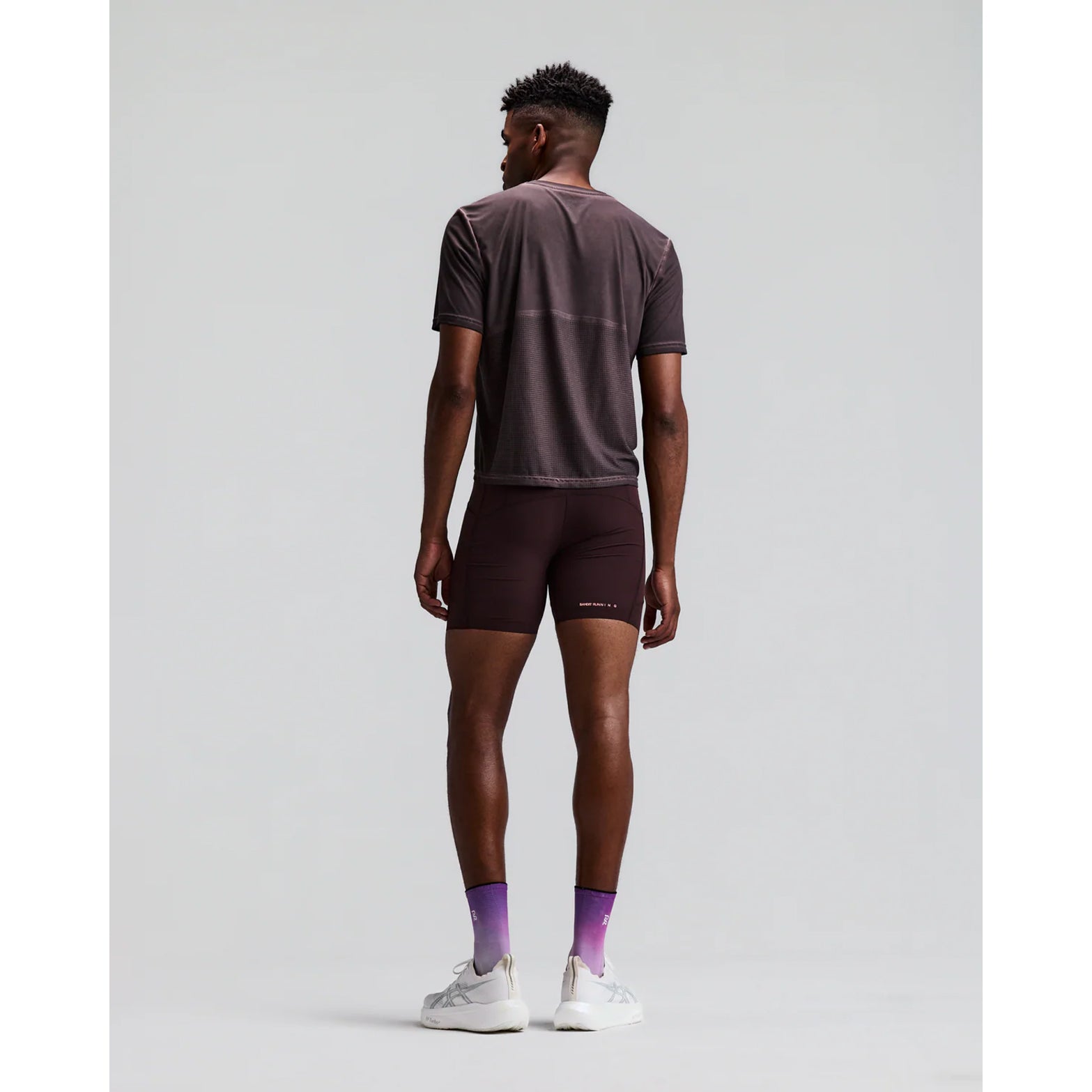 Men's Bandit SoLite Quarter Tights Espresso back full body view on male runner showing waterproof centre back zip pocket with GripDot hem technology and SoLite featherweight compression construction