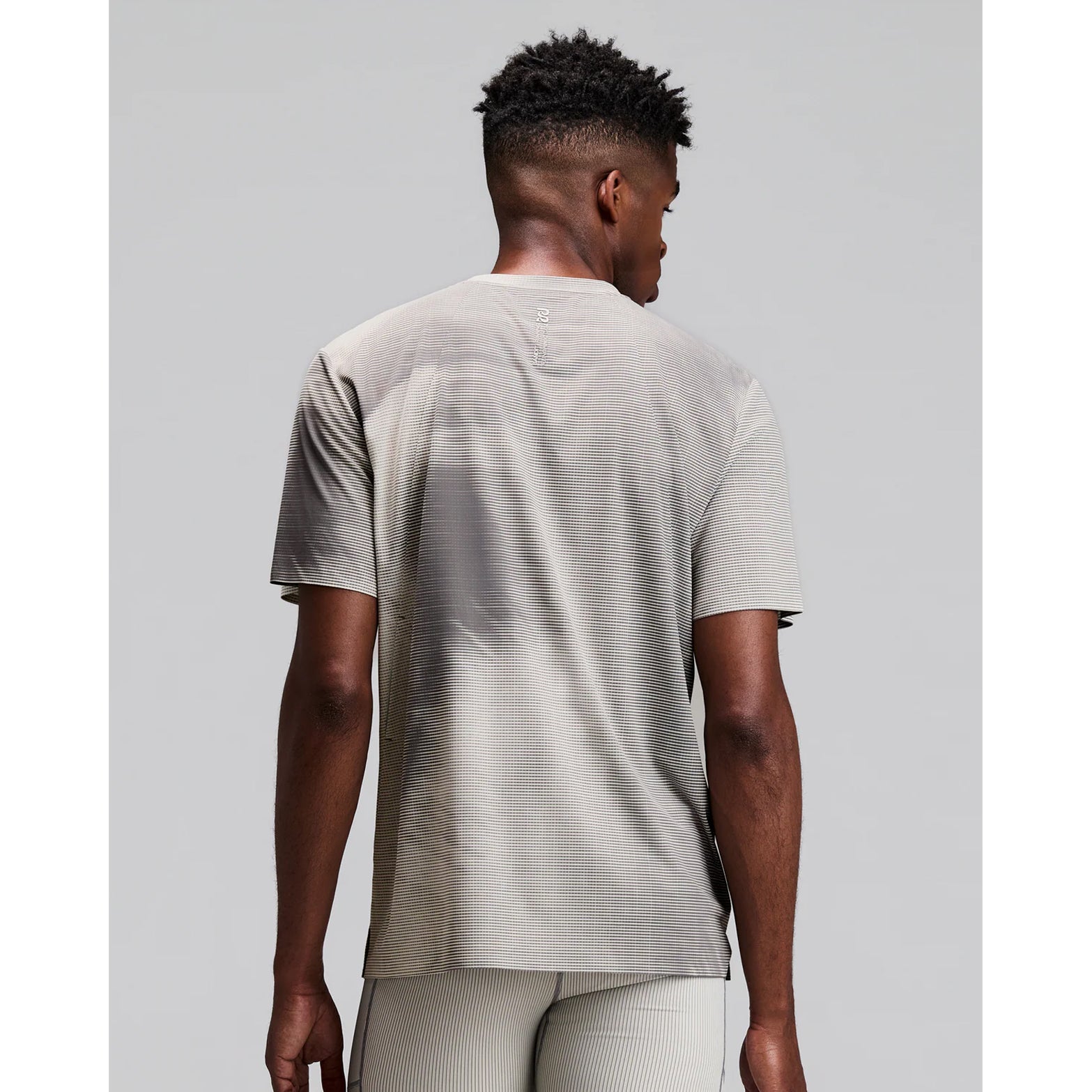 Men's Bandit Specter Performance Tee Slate Plaster back view on male runner showing reflective centre back graphic with lightweight Specter performance fabric and anti-cling sweat-wicking construction