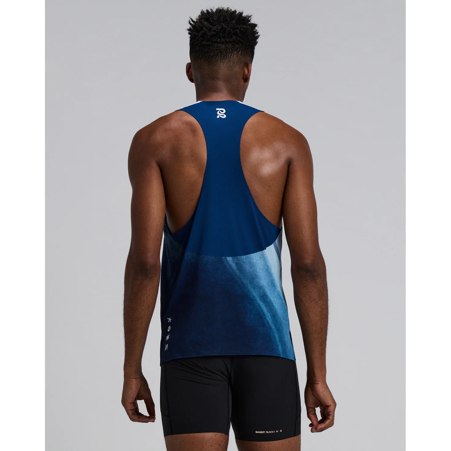 Bandit Specter Race Singlet men's in Undertow Ink Blue Multi — back view worn on model showing deep racerback fit, Acrofuse™ bonded seam construction, side slits and undertow ink blue multi Specter™ fabric
