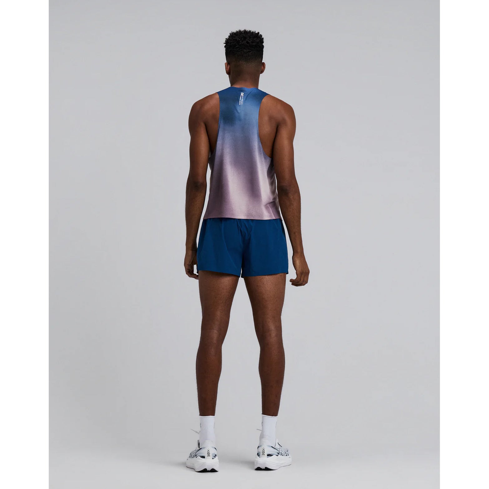Bandit Specter Shorty Race Singlet men's in Flow State Aegean Multi — full body back view worn on model showing deep racerback construction, side slits and flow state aegean multi Specter™ fabric in motion