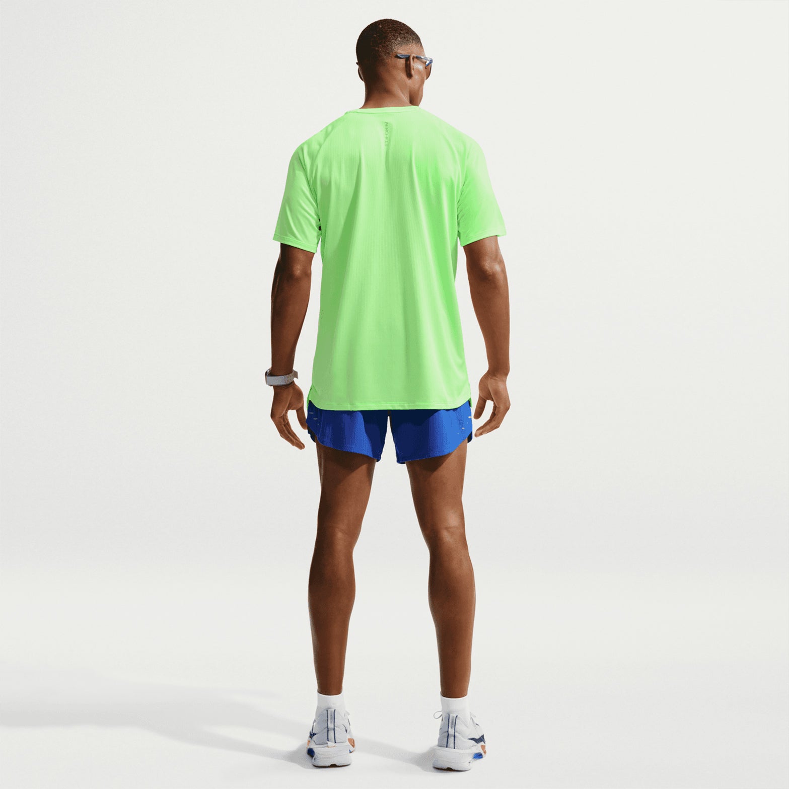Men's Nike Stride Aero-FIT Running Tee Volt Light Silver full body back view on male runner showing strategic back mesh zones with Aero-FIT technology for maximum breathability and active cooling during warm weather training