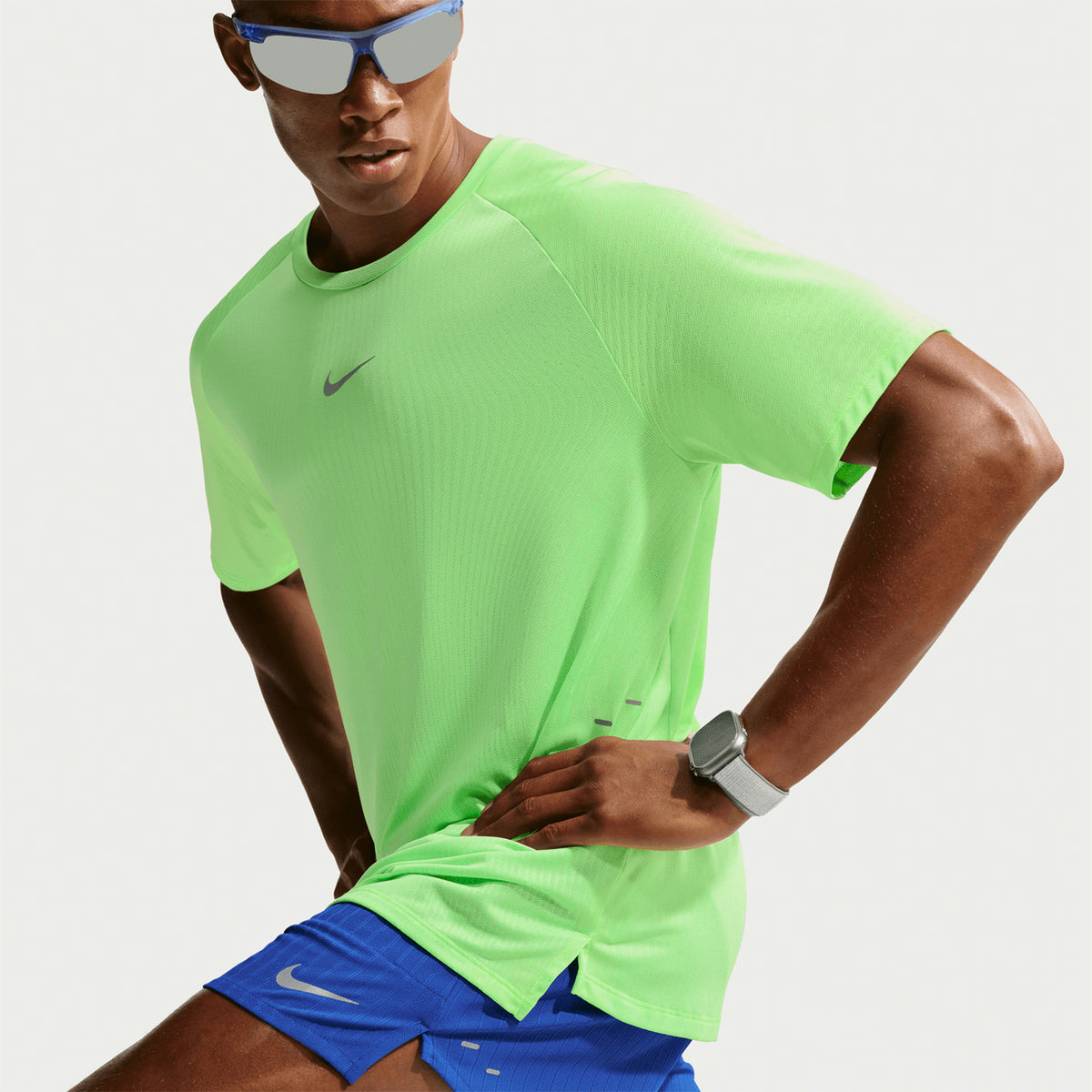 Men's Nike Stride Aero-FIT Running Tee Volt Light Silver side view on male runner showing side hem vents with lightweight Aero-FIT construction for unrestricted movement and airflow during running