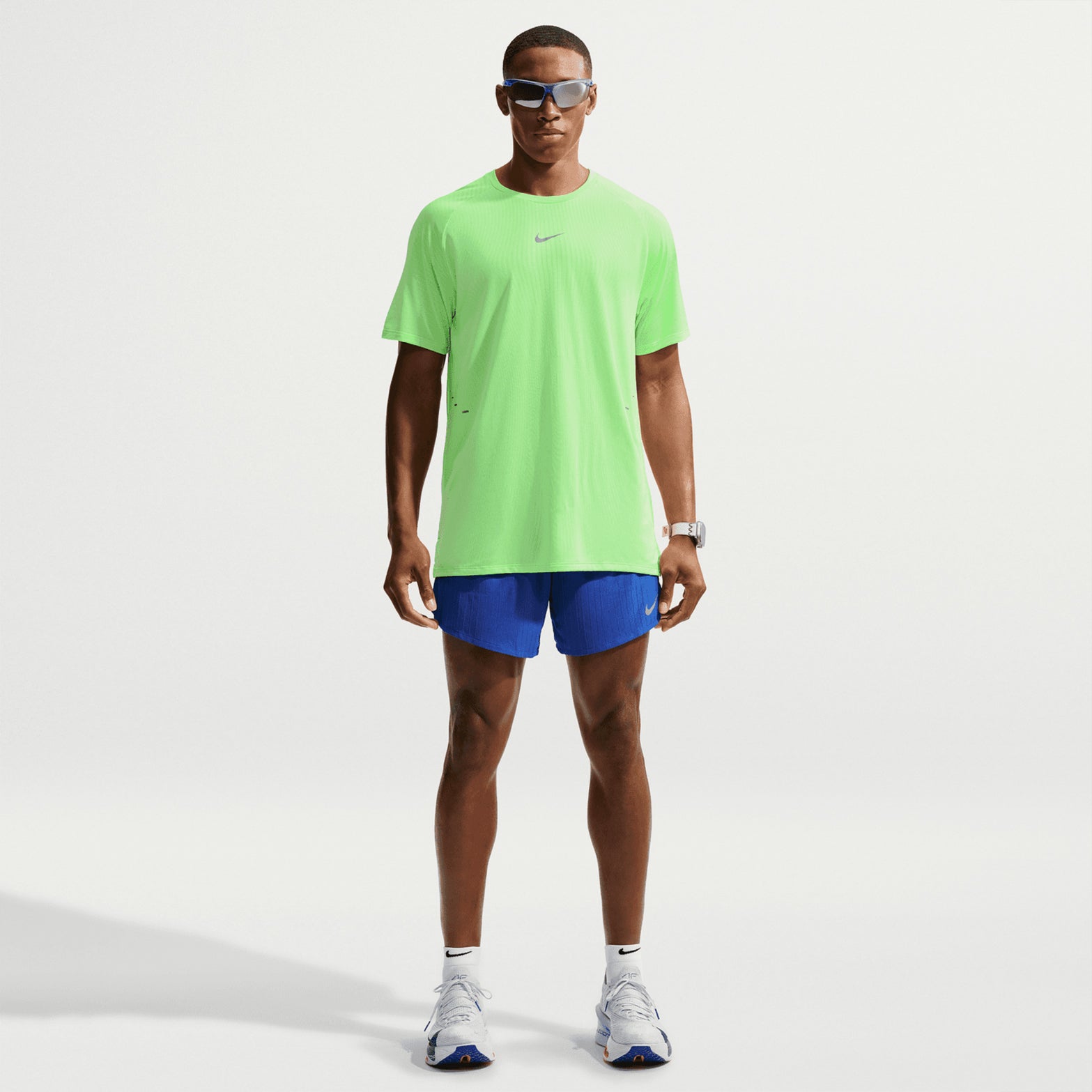 Men's Nike Stride Aero-FIT Running Tee Volt Light Silver full body view on male runner showing lightweight knit with strategic mesh zones and side hem vents for maximum breathability and unrestricted movement