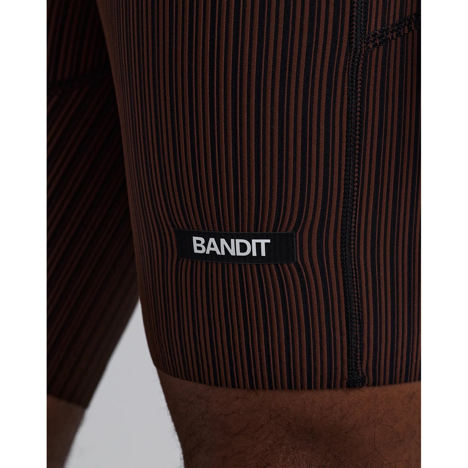 Bandit Striped Cadence 7 Pocket Half Tights men's in Cacao / Black — closeup showing custom-branded drawstring and silicone patch detail on cacao and black Striped Cadence™ ribbed knit waistband