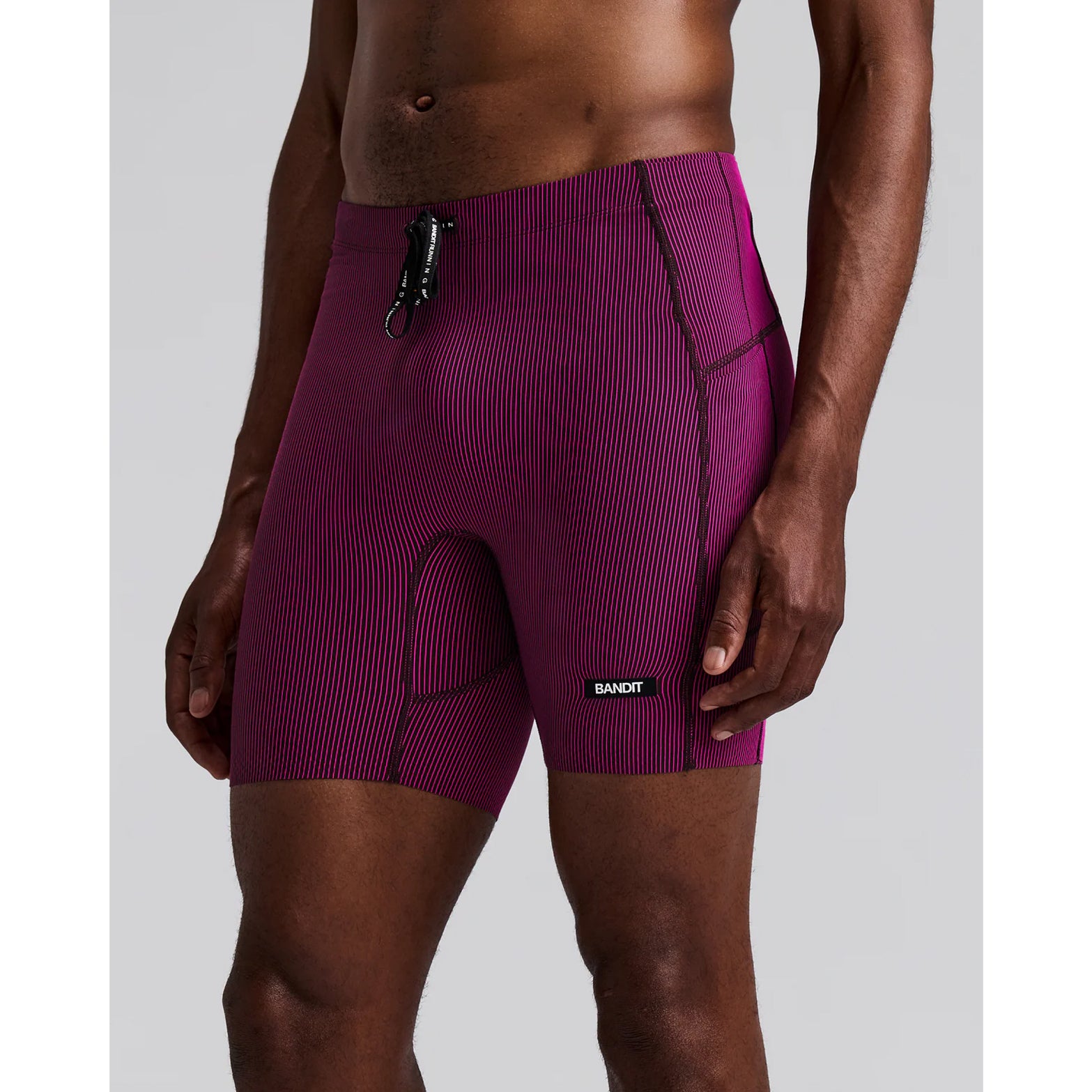 Men's Bandit Striped Cadence Quarter Tights Espresso Azalea front view on male runner showing Striped Cadence ribbed compression with GripDot laser-cut hems and custom drawstring waistband for race day performance