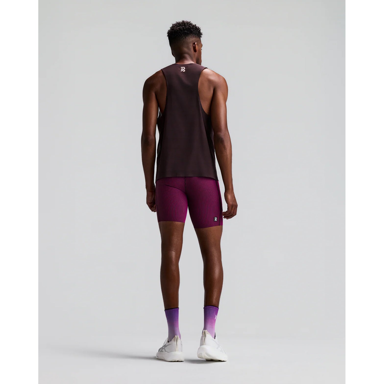 Men's Bandit Striped Cadence Quarter Tights Espresso Azalea back full body view on male runner showing waterproof phone pockets with tee loop, gel pockets and GripDot laser-cut hems for long-distance running