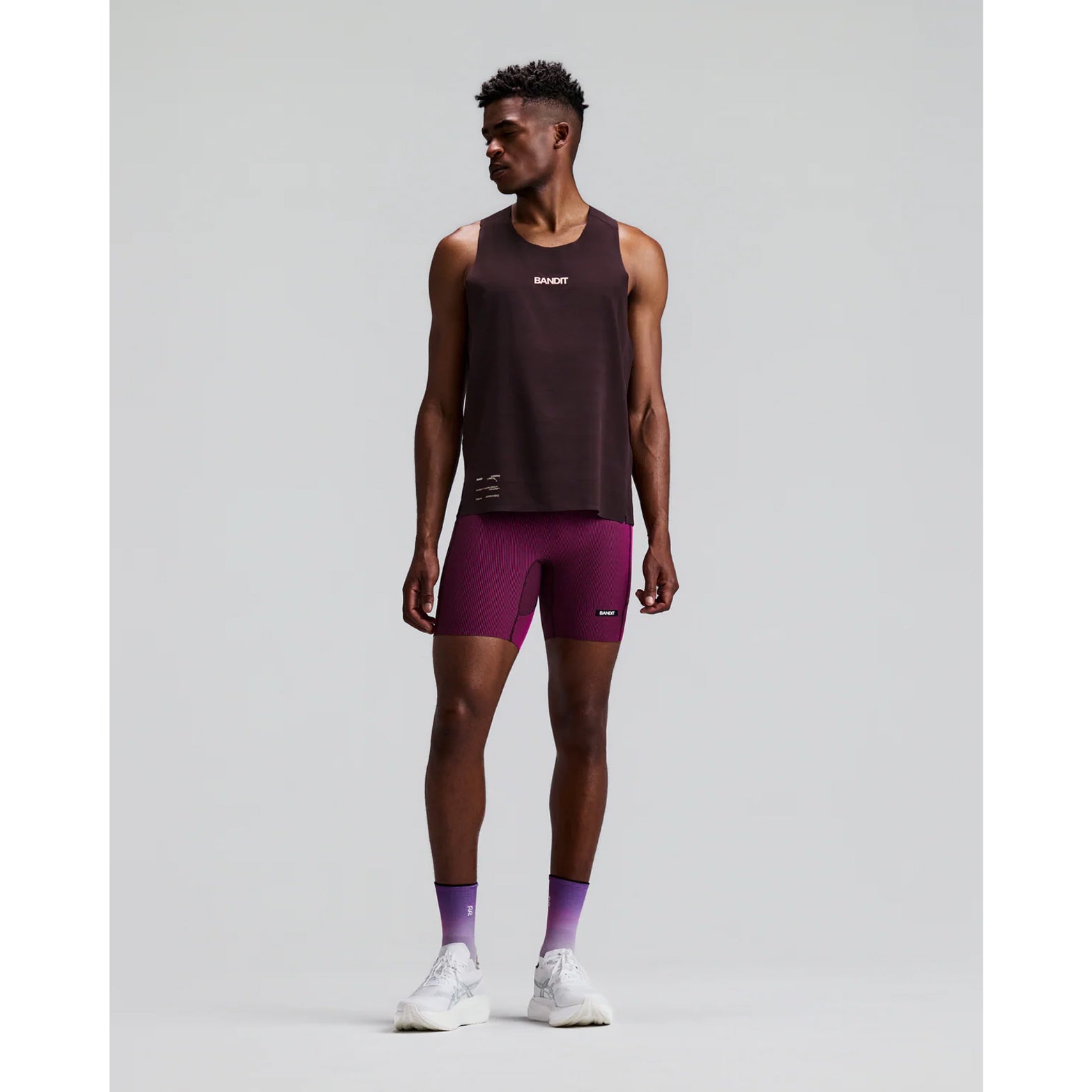 Men's Bandit Striped Cadence Quarter Tights Espresso Azalea front full body view on male runner showing Striped Cadence ribbed compression with GripDot hems and seven-pocket system for road running and racing
