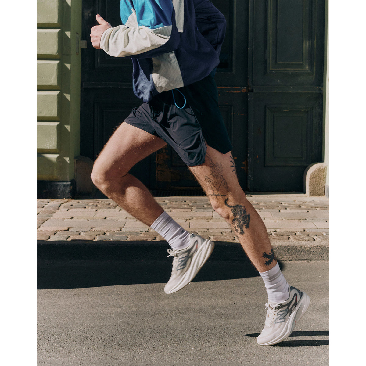 Men's New Balance SuperComp Rebel Running Shoes Angora Slate Grey side view on male runner showing Infinion foam with precision plate and rocker profile for propulsive snappy feel across tempo training and race day efforts