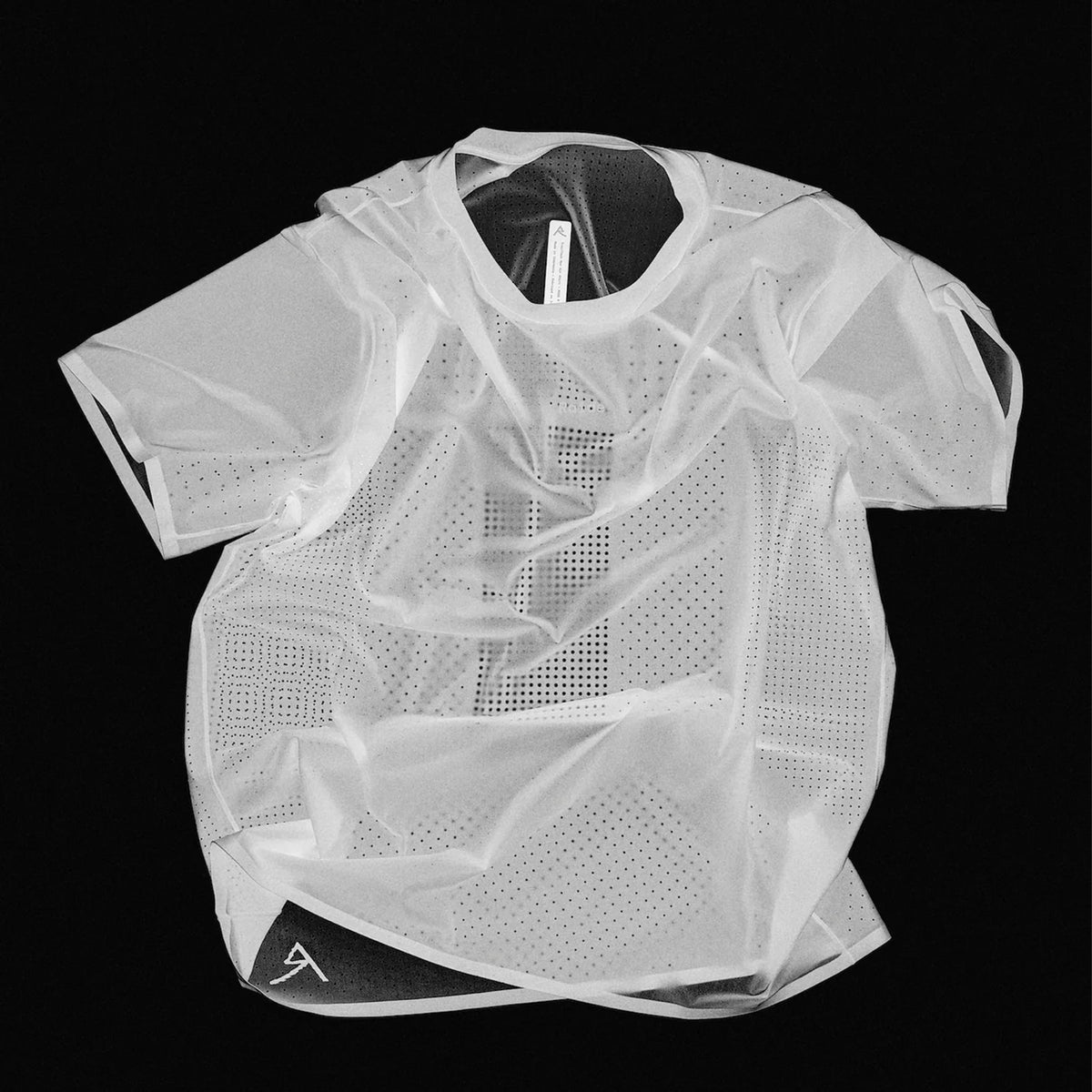 Men's Raide Thermal Dispersion Tee Black negative product shot highlighting body-mapped laser-cut perforation pattern showing concentrated centre back ventilation zones and strategic hole placement for maximum evaporative cooling during running