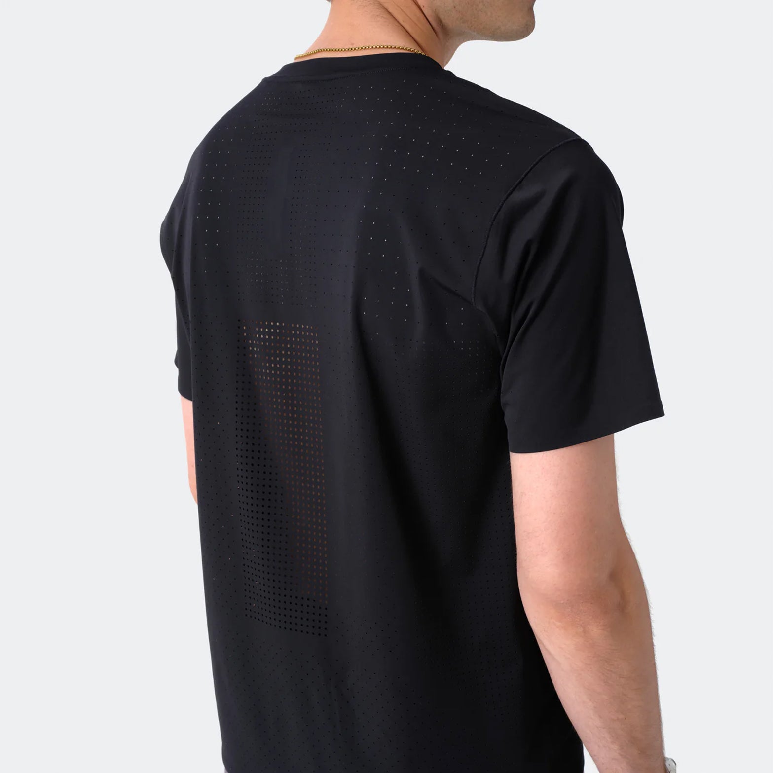 Men's Raide Thermal Dispersion Tee Black back view on male runner showing densely perforated centre back heat zone with body-mapped laser-cut ventilation for evaporative cooling during sustained efforts