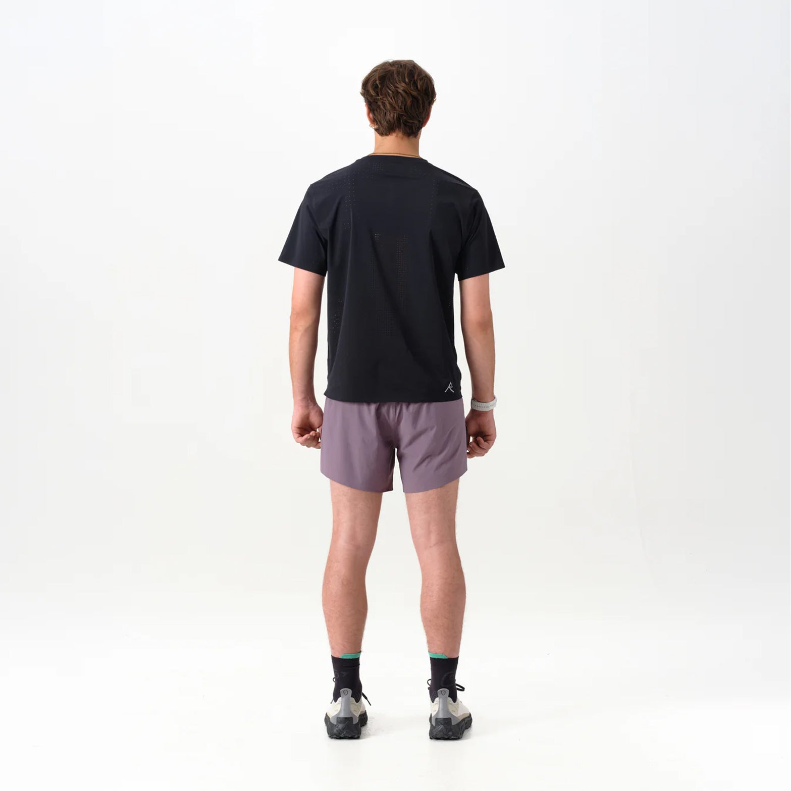 Men's Raide Thermal Dispersion Tee Black back full body view on male runner showing body-mapped centre back perforations with reflective branding and Italian-knit microfibre for evaporative cooling during road running