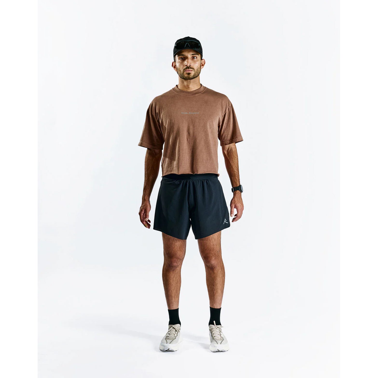 Raide TrailTech Short men's in Black — full body front view worn on model showing 5.25 inch silhouette, laser-perforated waistband and pocket placement in motion on trail