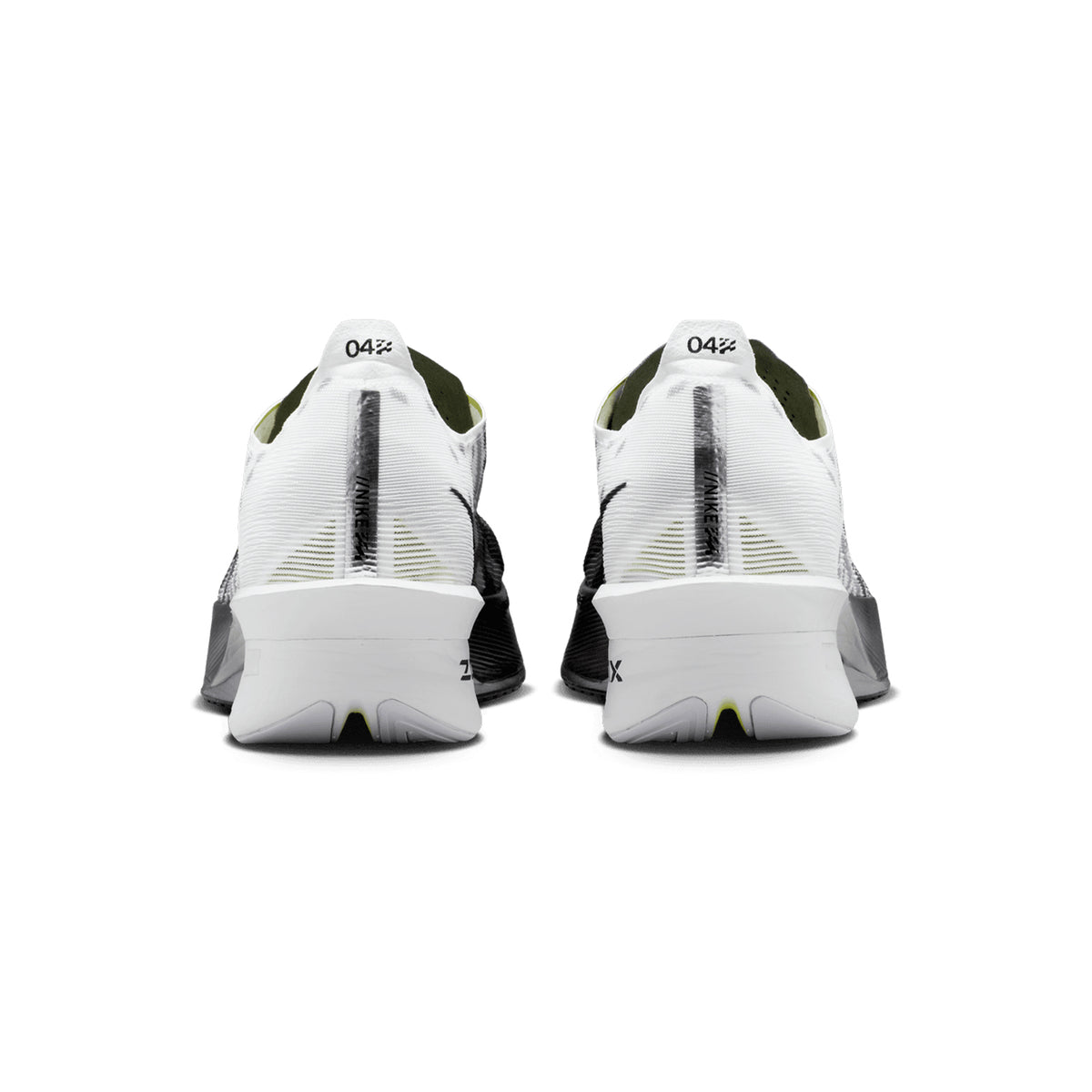 A pair of Nike Men’s Vaporfly 4 SE Running Shoes in Black, White, and Smoke Grey are displayed side by side on a plain white background. Viewed from the back, these athletic racing shoes showcase black accents and size labels marked 04½ on the heels. Featuring a carbon fibre Flyplate for enhanced performance, they are designed to deliver superior speed and efficiency.