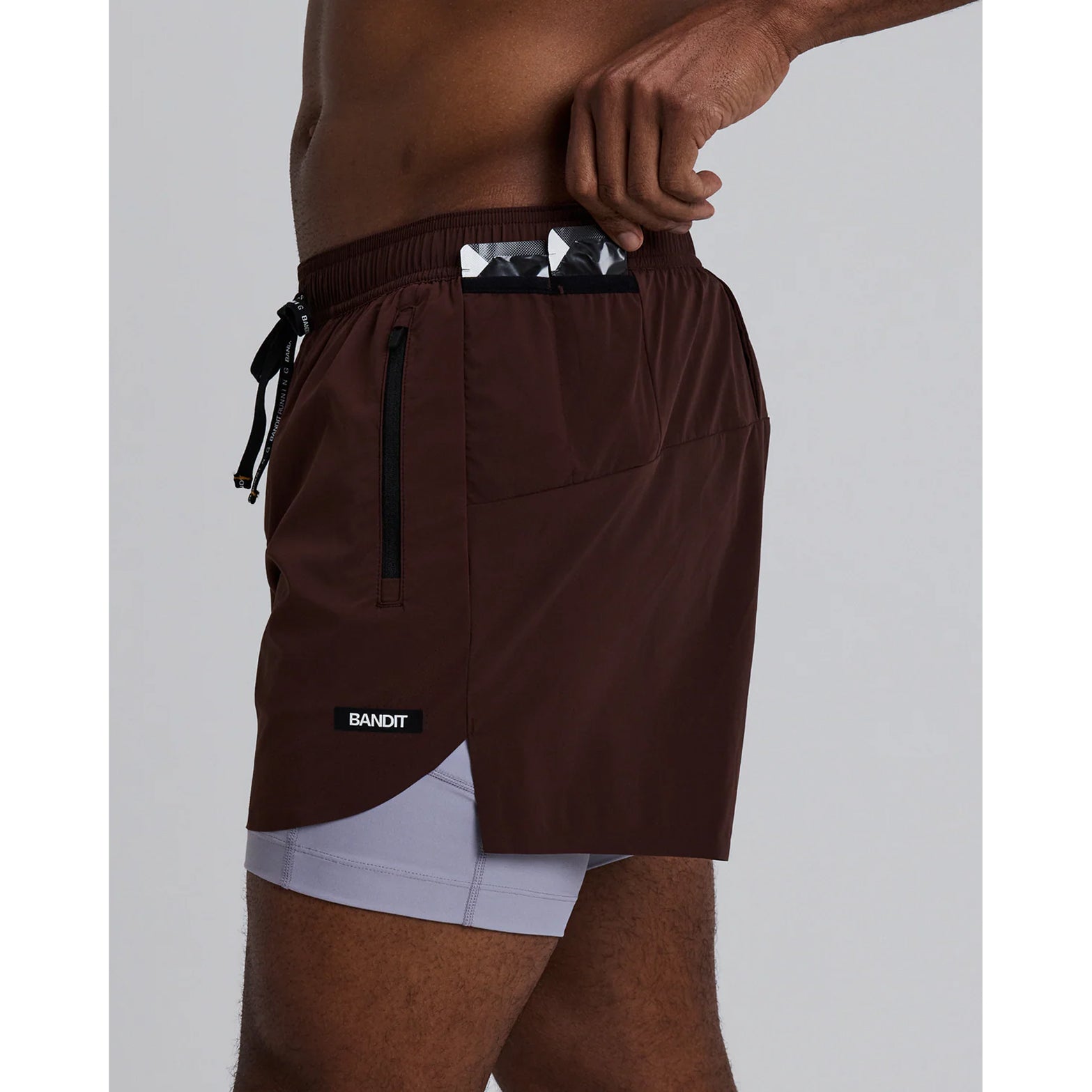 Men's Bandit Vento Next Gen 2-in-1 Run Short Cacao side view on male runner showing SoLite compression liner, four-way stretch Vento fabric and ride-up prevention grip technology
