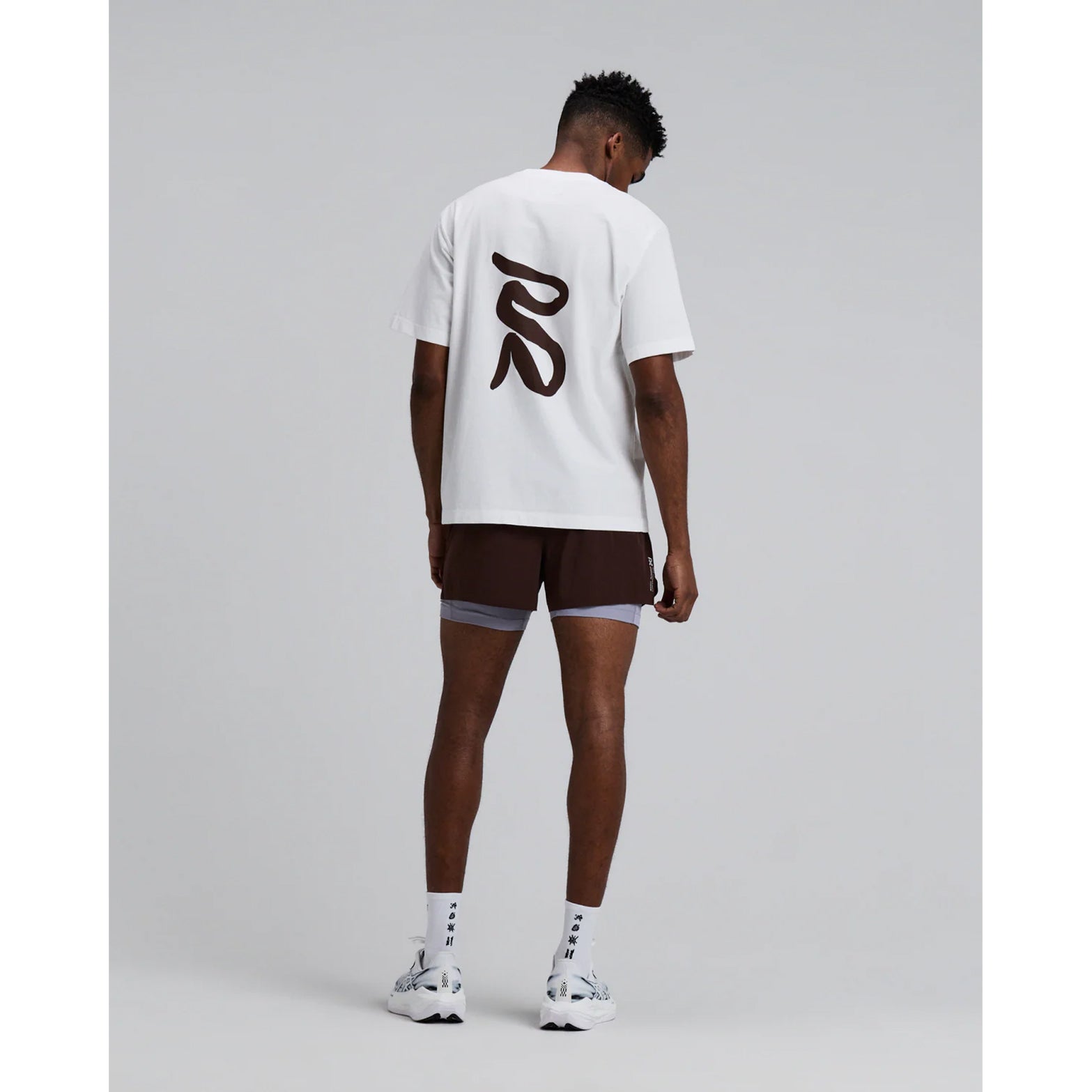 Men's Bandit Vento Next Gen 2-in-1 Run Short Cacao full body back view on male runner showing comprehensive pocket system with 2 phone and 4 gel pockets plus ride-up prevention grip