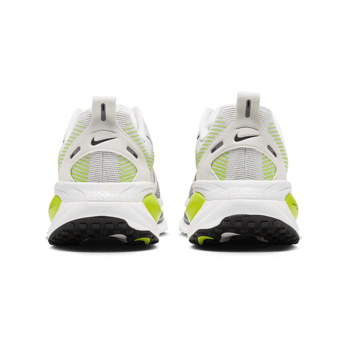 Back view of the Nike Men’s Vomero 18 Running Shoes in Photon Dust, Black, and Volt—featuring white and gray uppers with neon yellow accents, black soles, and a small black Nike Swoosh logo on each heel. Designed as an everyday trainer with dual-density cushioning inspired by previous Vomero models for superior comfort.