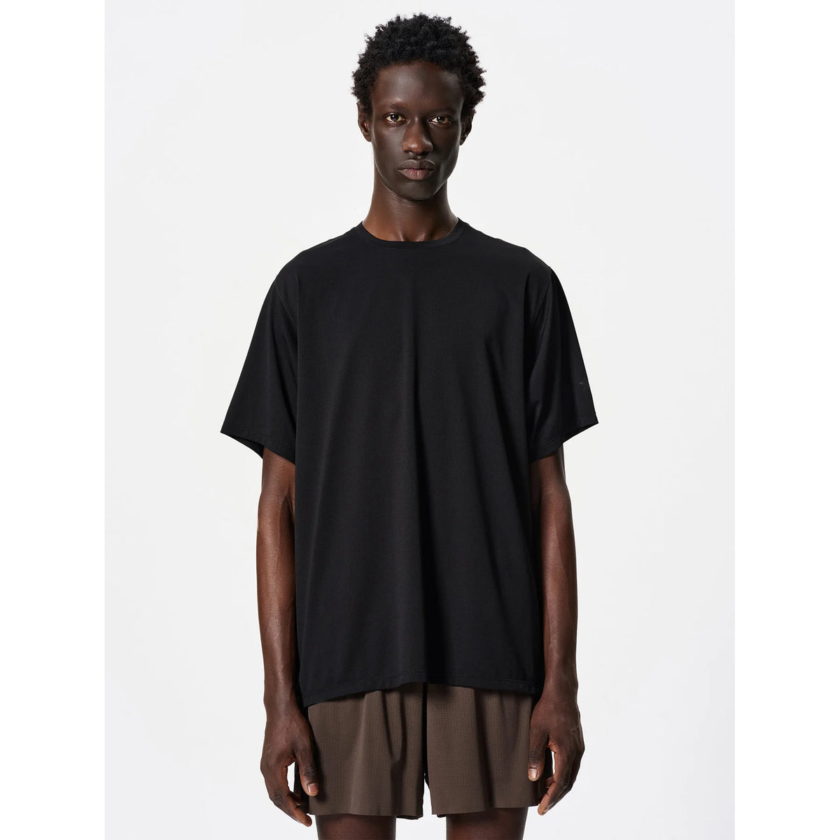Goldwin Men's WF-Dry Tee Black upper body view on male runner showing modified raglan sleeves, forearm wedges and backpack-compatible design with quick-dry waffle fabric construction