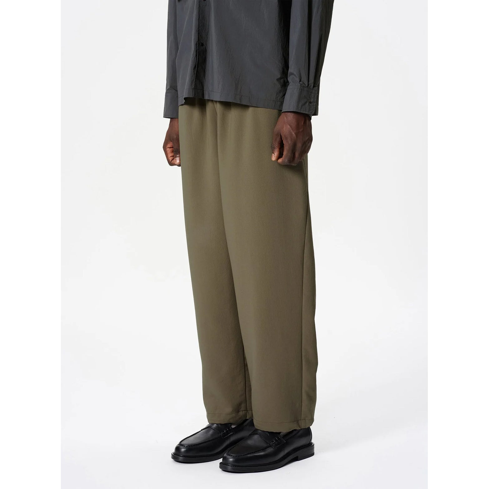 Goldwin Men's Wide Ankle Easy Pants Sand Land side view on male model showing mechanical stretch fabric with mesh structure for breathability