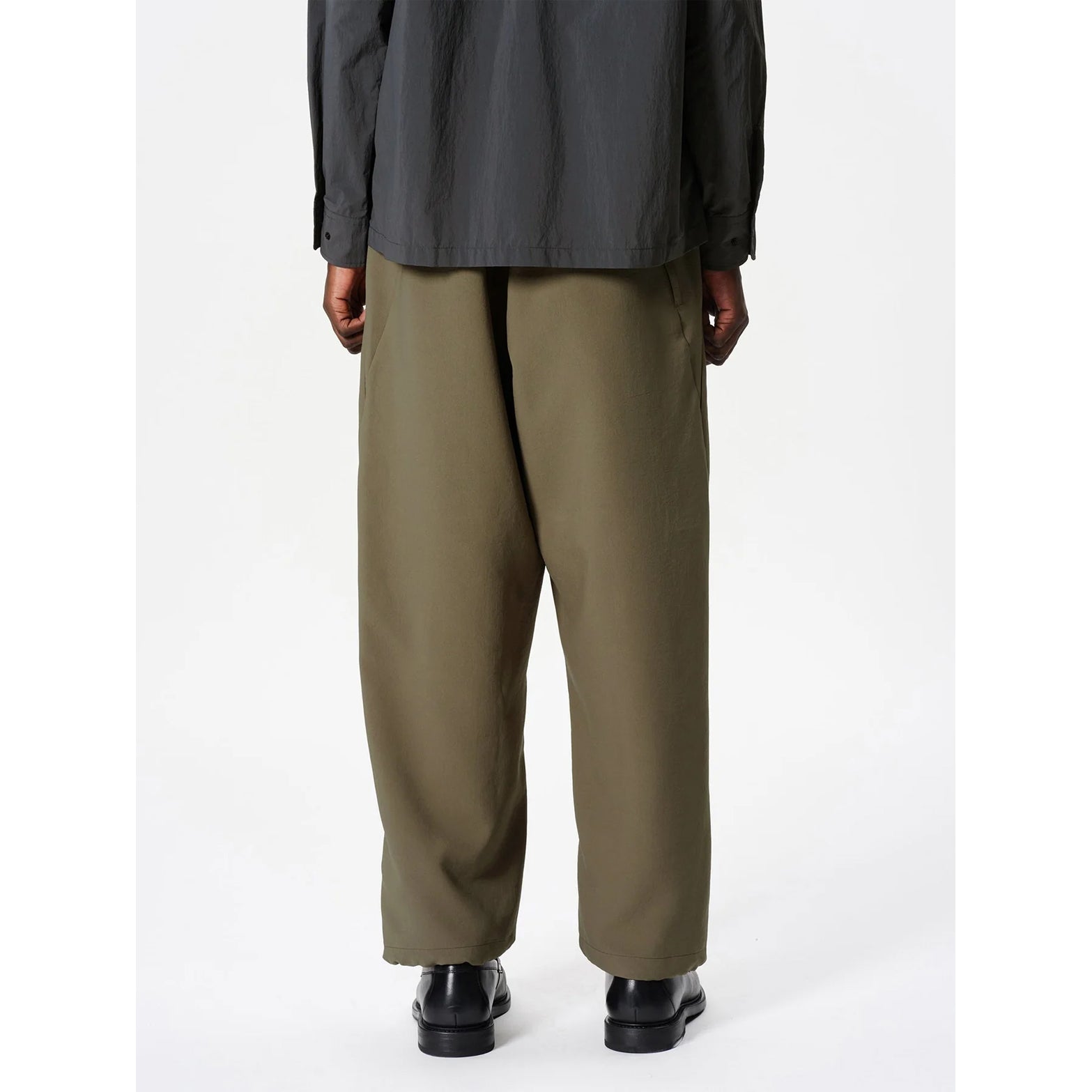 Goldwin Men's Wide Ankle Easy Pants Sand Land back view on male model showing adjustable drawstring hem and UV protection tested construction