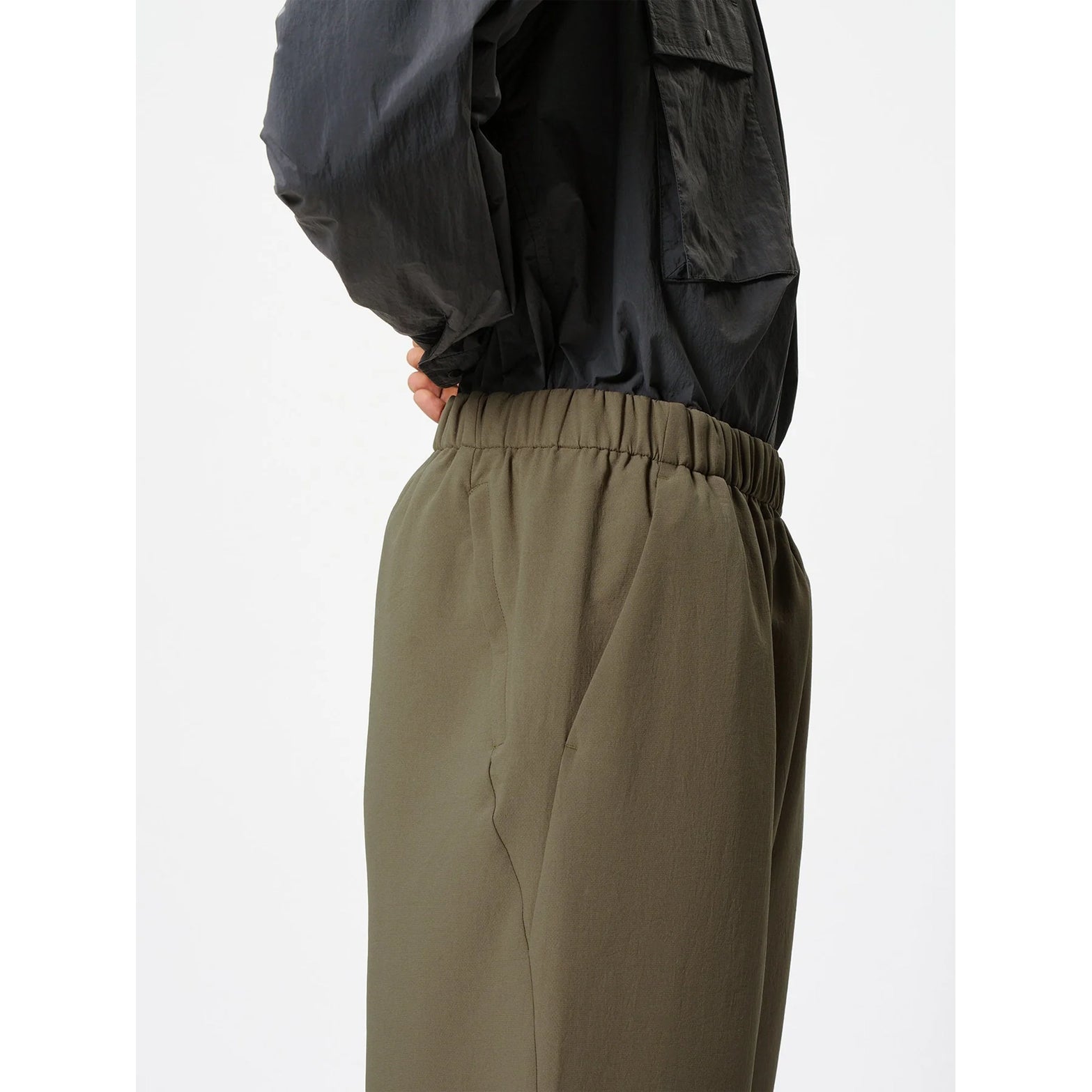 Goldwin Men's Wide Ankle Easy Pants Sand Land side close-up showing 2-layer softshell fabric with water-repellent properties and quarter-length ankle inseam