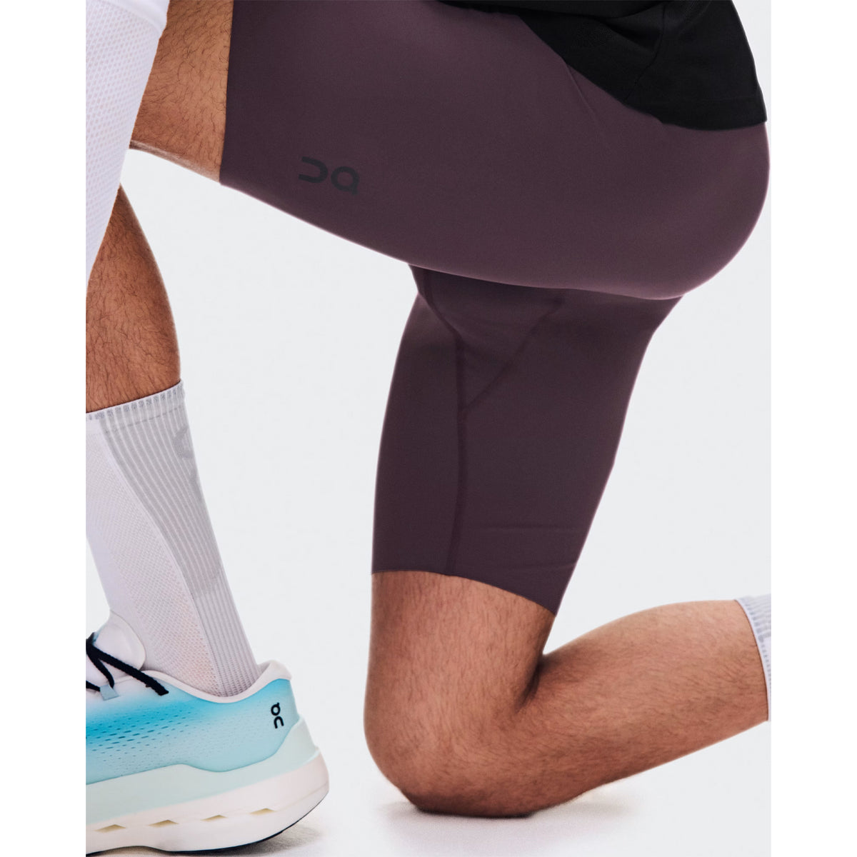 Men's On Zero Half Tights Urchin side view on male runner showing lightweight technical fabric with adjustable waistband and bonded back pocket construction for distraction-free race day running