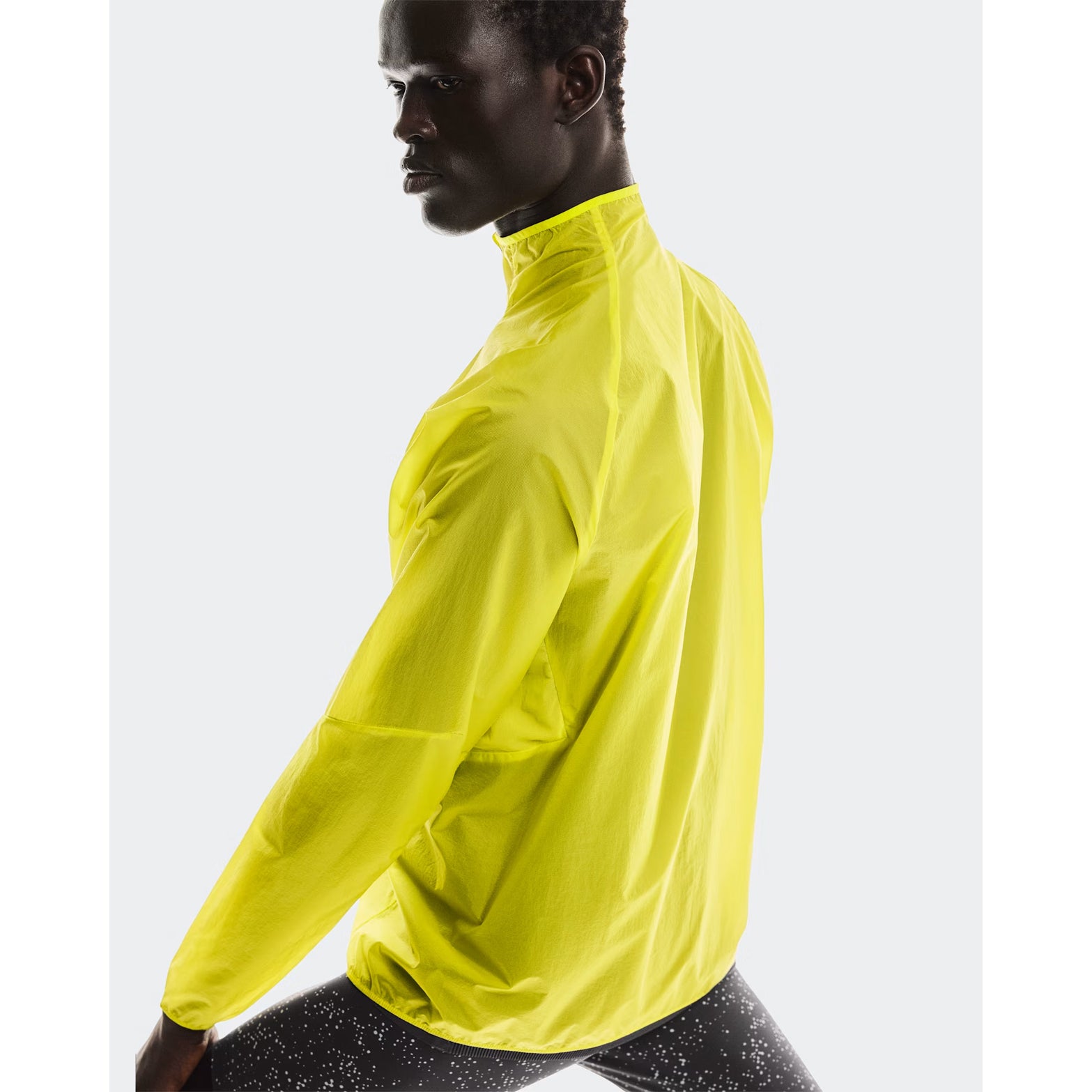 Men's On Zero Jacket Lime back view on male runner showing breathable windproof fabric with reflective details for visibility