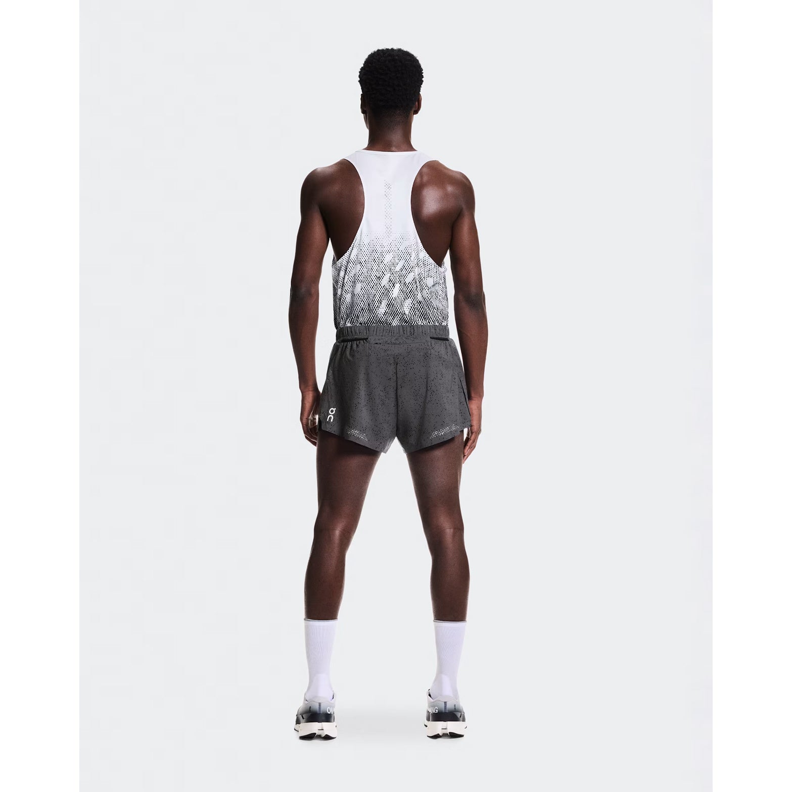 Men's On Zero Shorts Grey Black full body back view on male runner showing zip pocket and two mesh gel pockets for storage